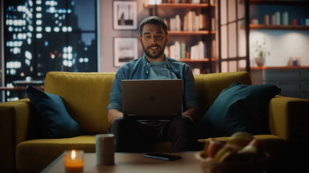 Professional working on a laptop in a modern living room setting for Expedient cloud services commercial