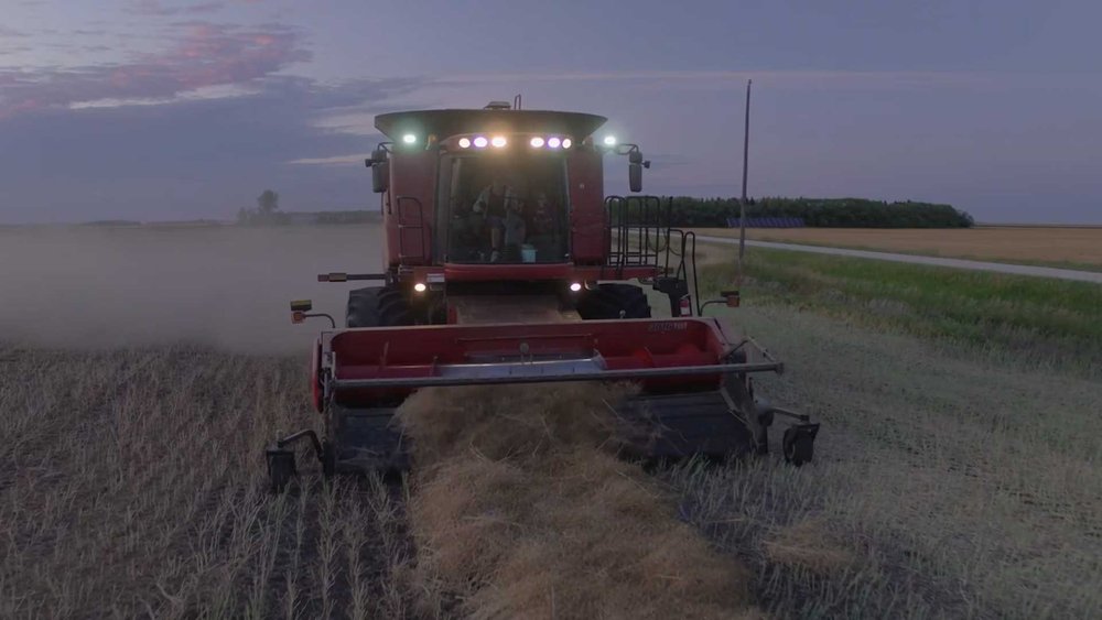 A tractor harvesting a field at dusk for Expedient marketing video
