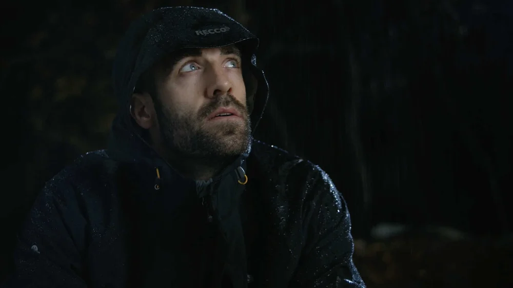 Outdoor commercial video still showing camper wearing Nor’easter 3-in-1 jacket during stormy conditions