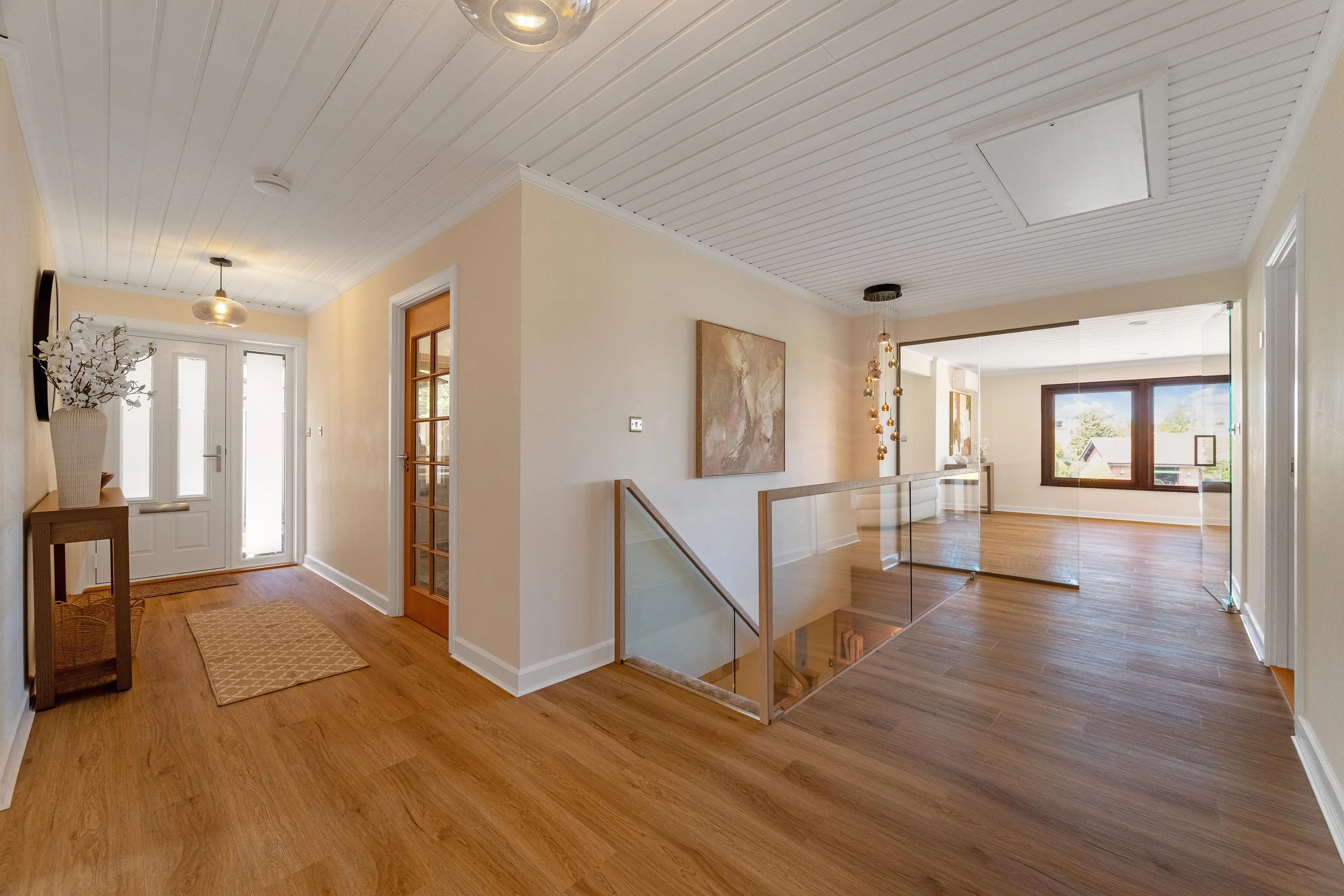 Hallway after refurbishment - with oak flooring and glass balustrade - The Chic Relic UK