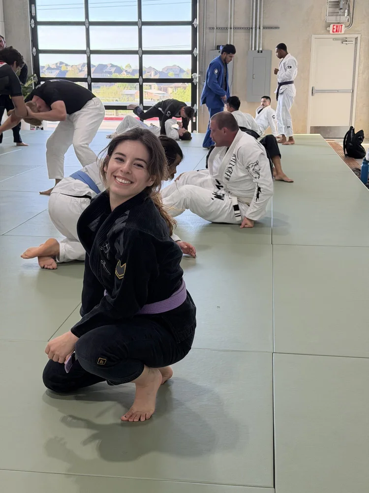 A purple belt student smiling during an adult jiu jitsu class at Practice Jiu Jitsu in Georgetown, TX