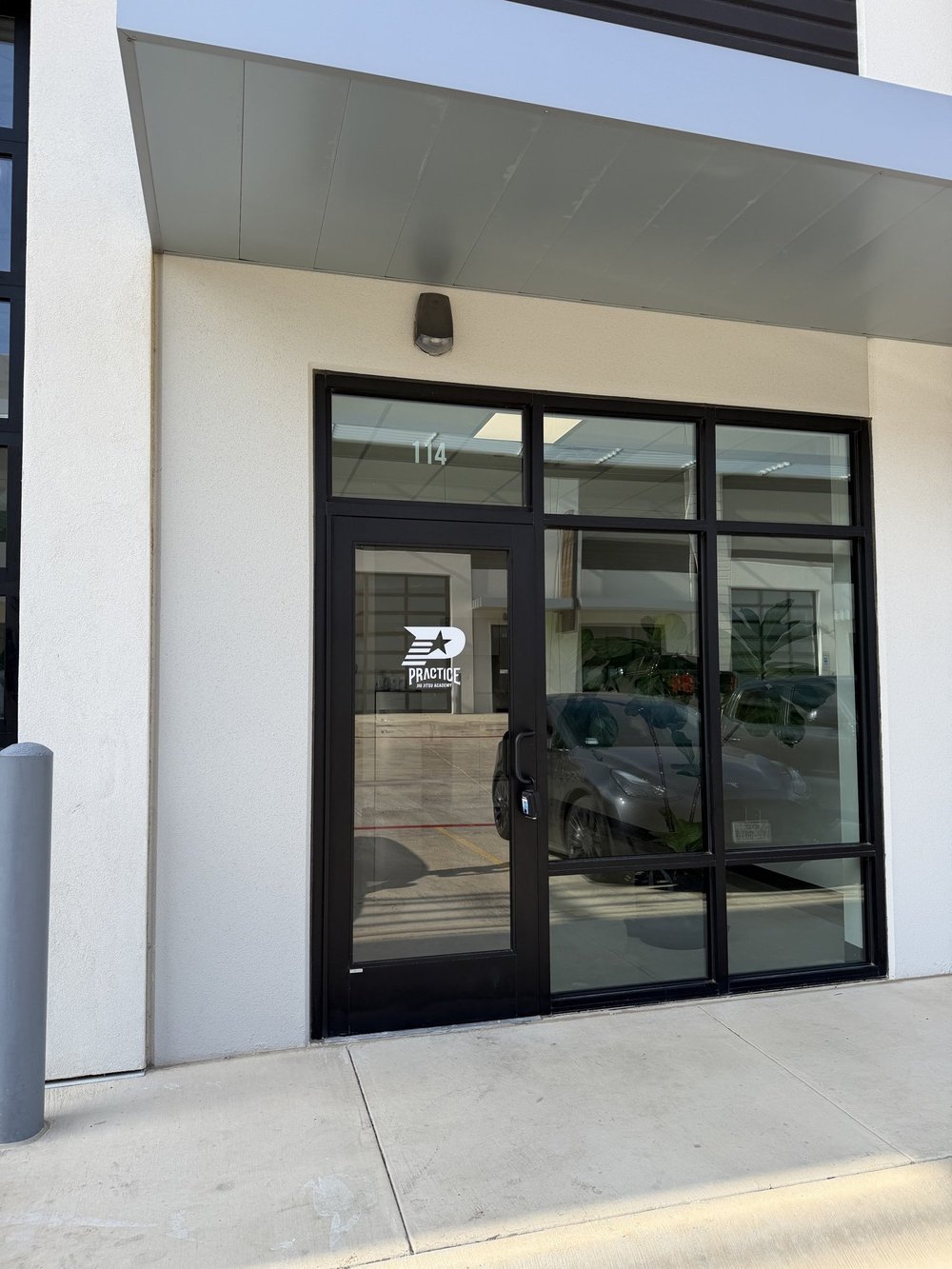 The entrance to Practice Jiu Jitsu at Suite 114, 1301 Blue Ridge Dr in Georgetown, TX, with the Practice logo on the glass door