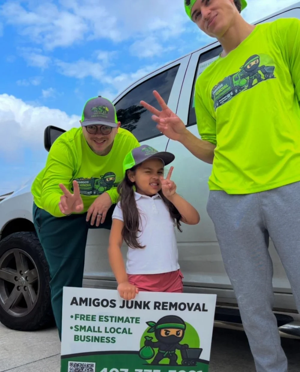 The Amigos Junk Removal family crew with their Free Estimate sign