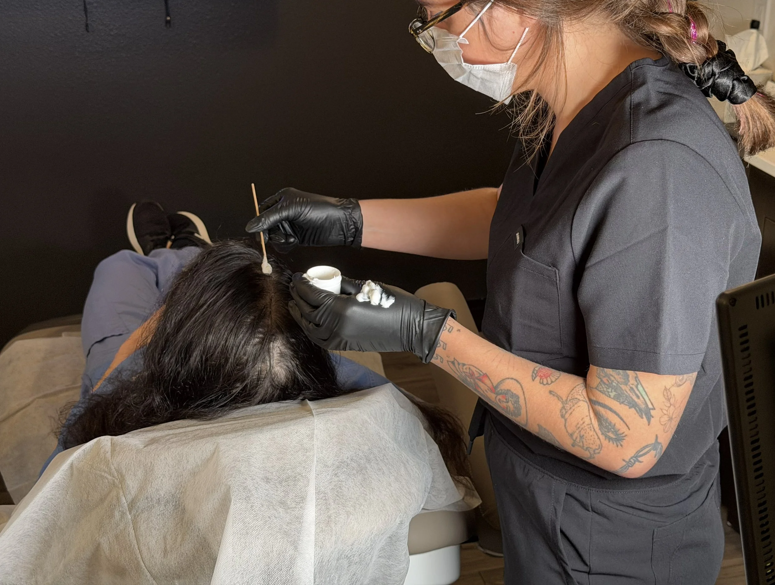Subtle Return practitioner preparing and numbing a real client before scalp micro-shading treatment