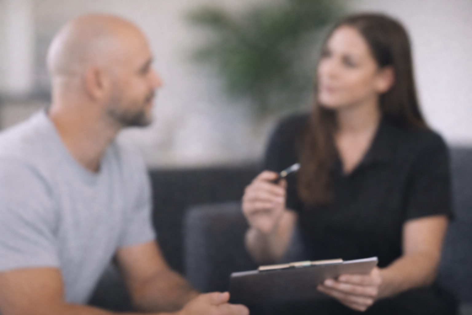 A man receives a consultation for hairline and visual density from a professional Subtle Return practioner. She helps him assess his goals, current hair pattern, hair-loss, and balding, and determines if hairline and visual density is the right path forward.