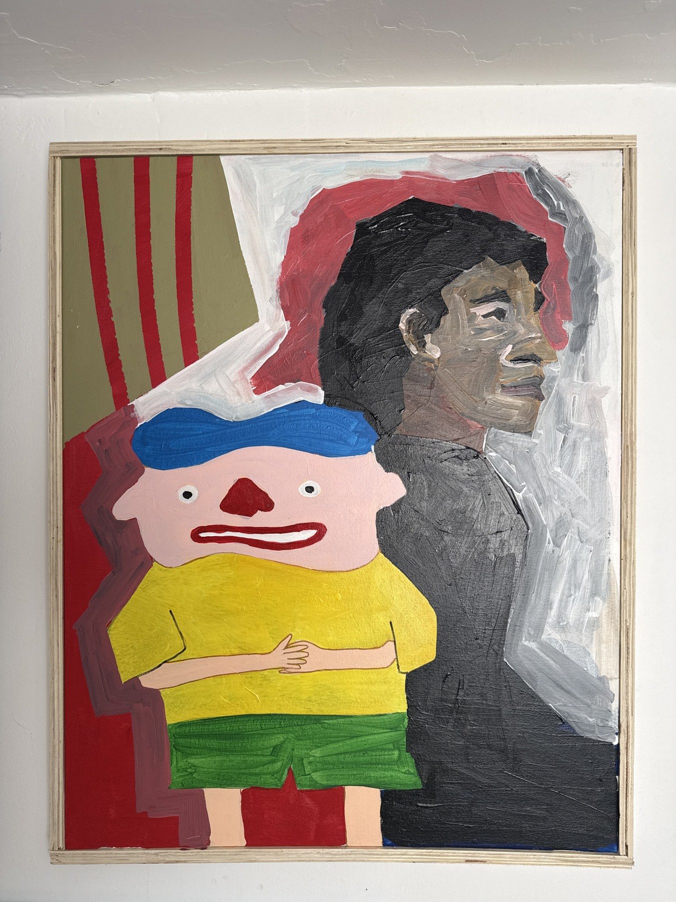 Framed expressive portrait beside a bright toy-like figure