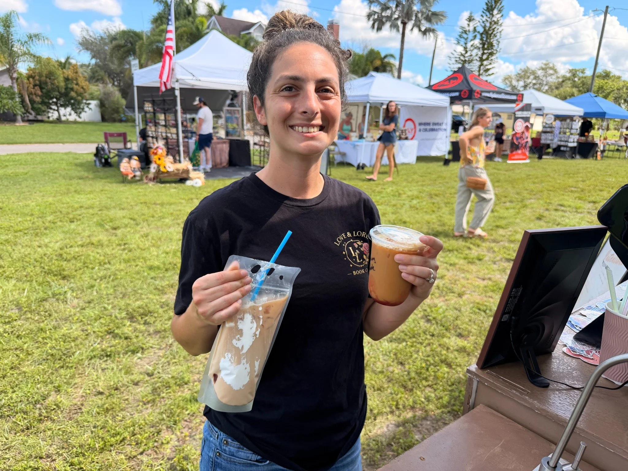 A guest holding handcrafted drinks from Pour Intentions at the market