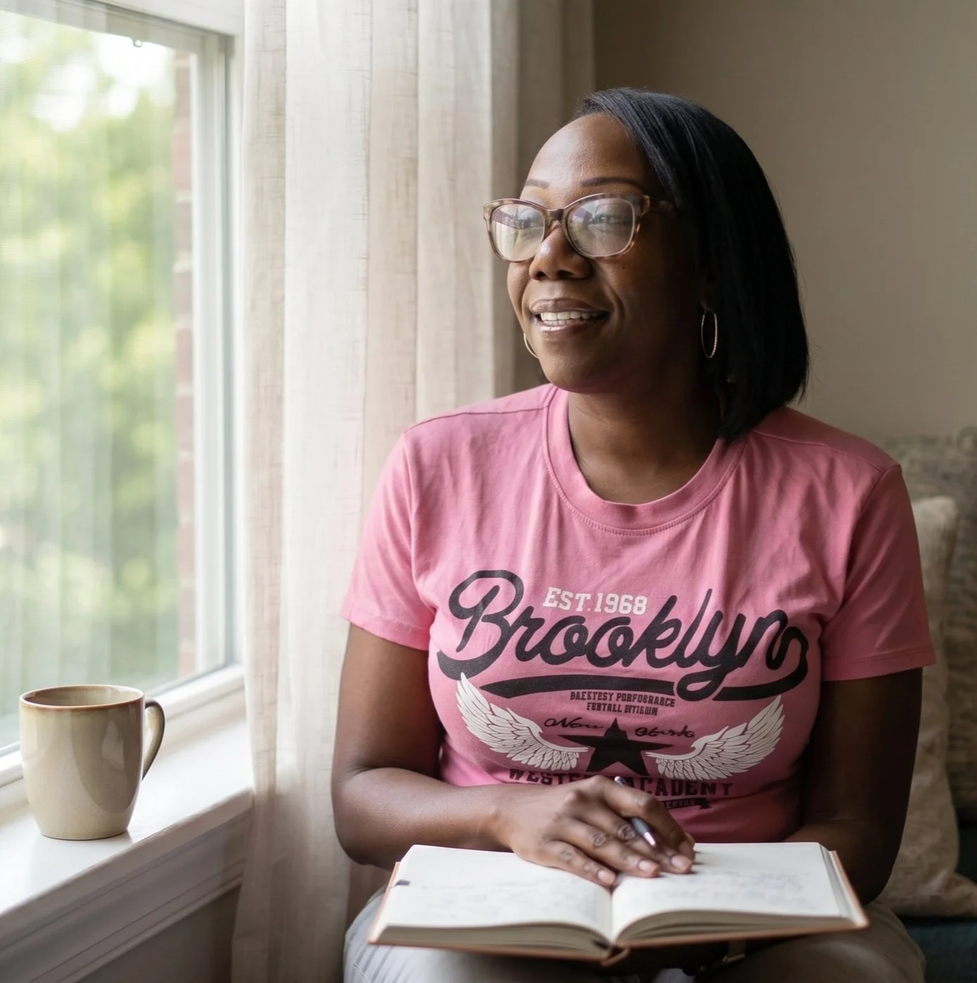 A woman smiling by a sunny window
