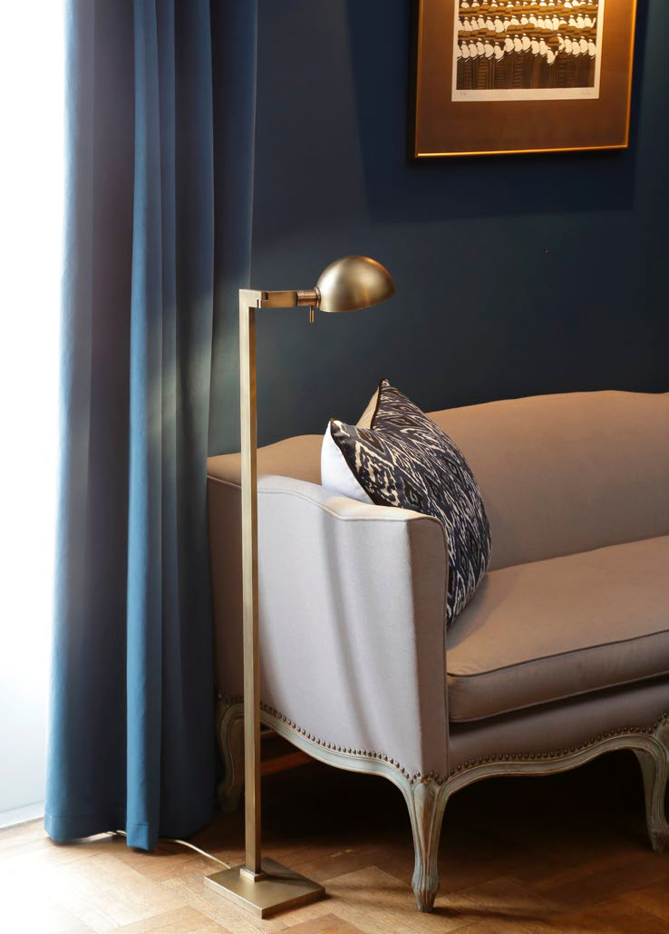 Christopher Hyland floor lamp in a brass finish beside a sofa