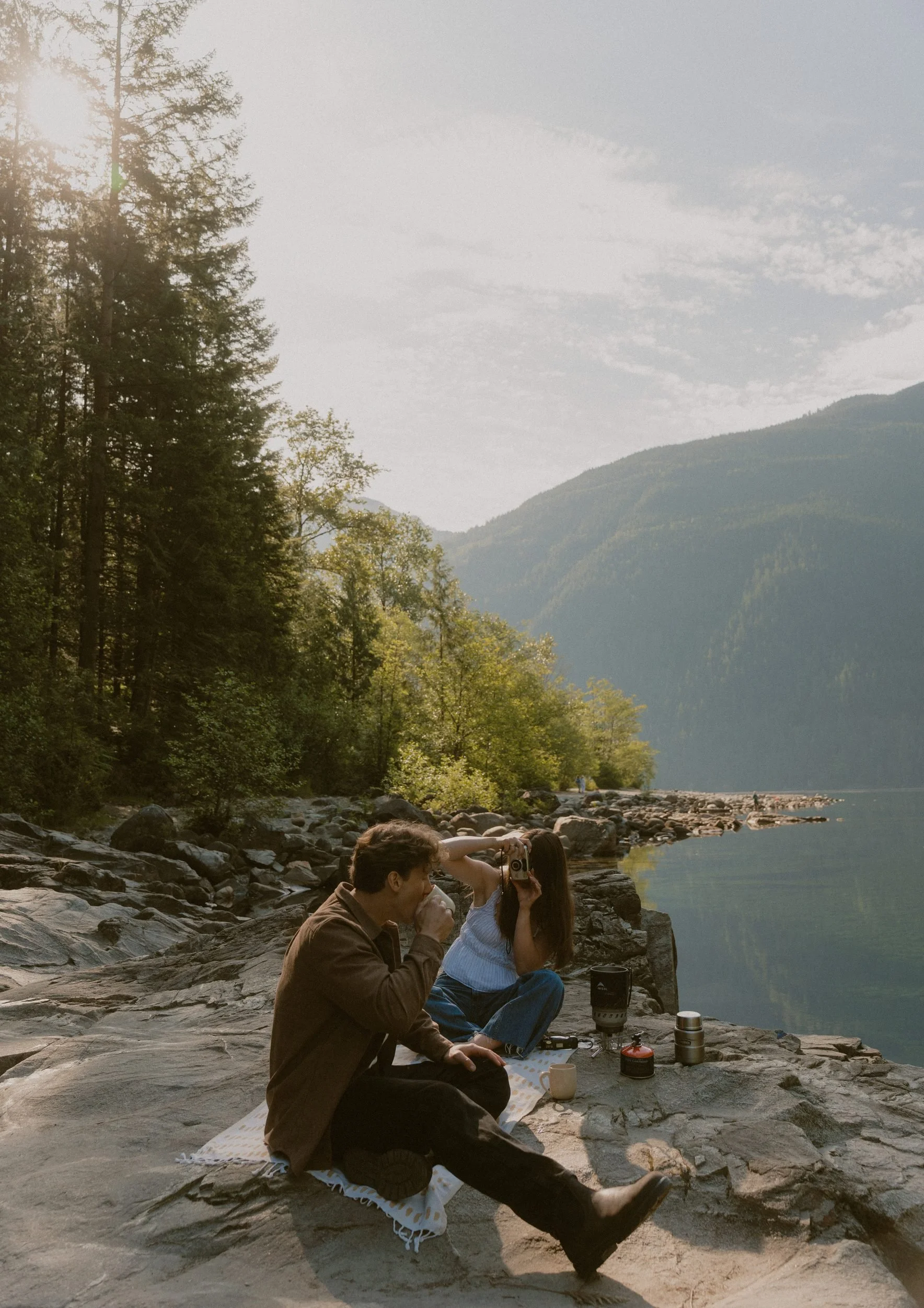 Couple sharing a quiet picnic beside a mountain lake