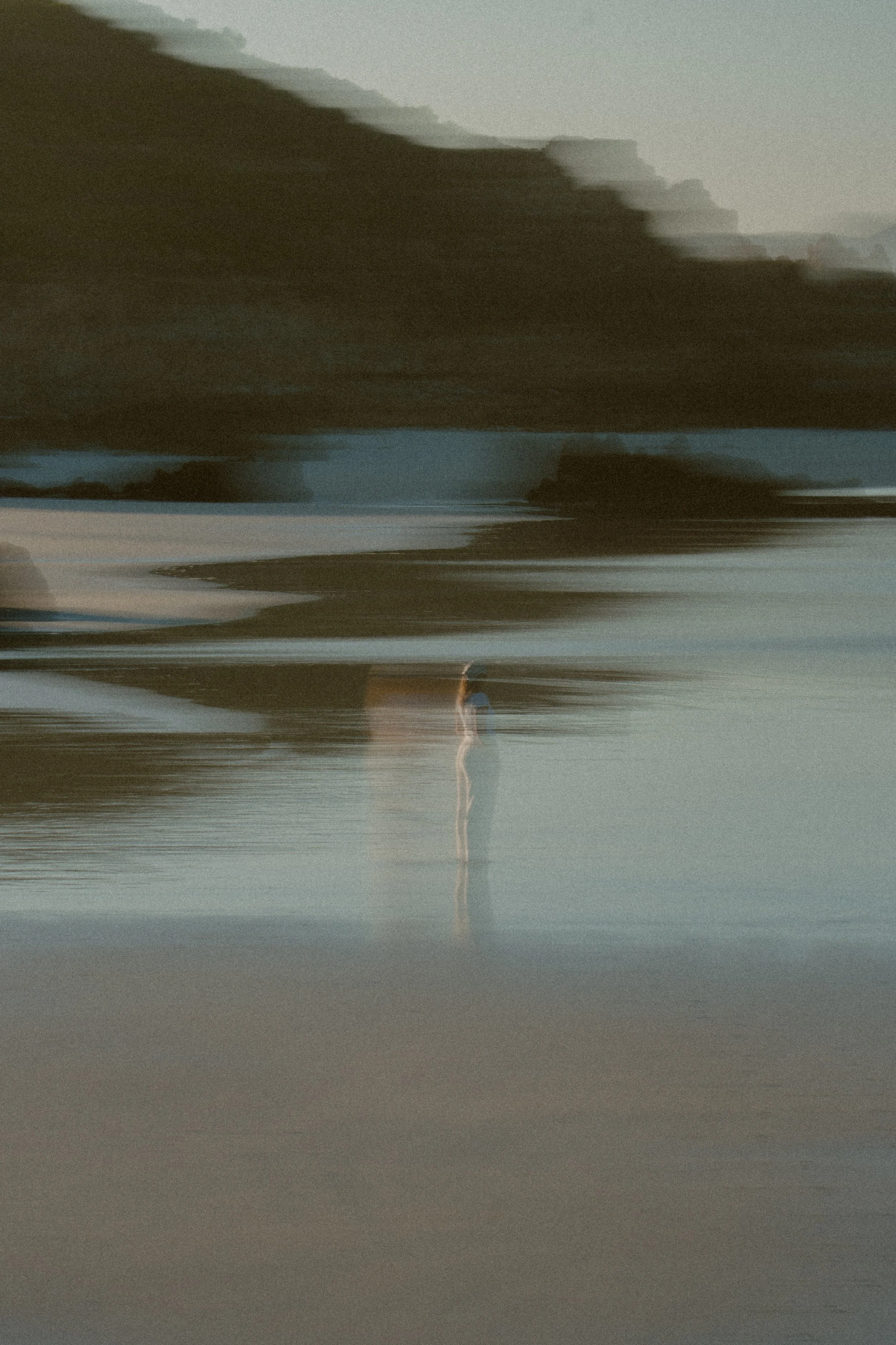 Abby standing on wet sand beside the sea in a motion-blurred photograph