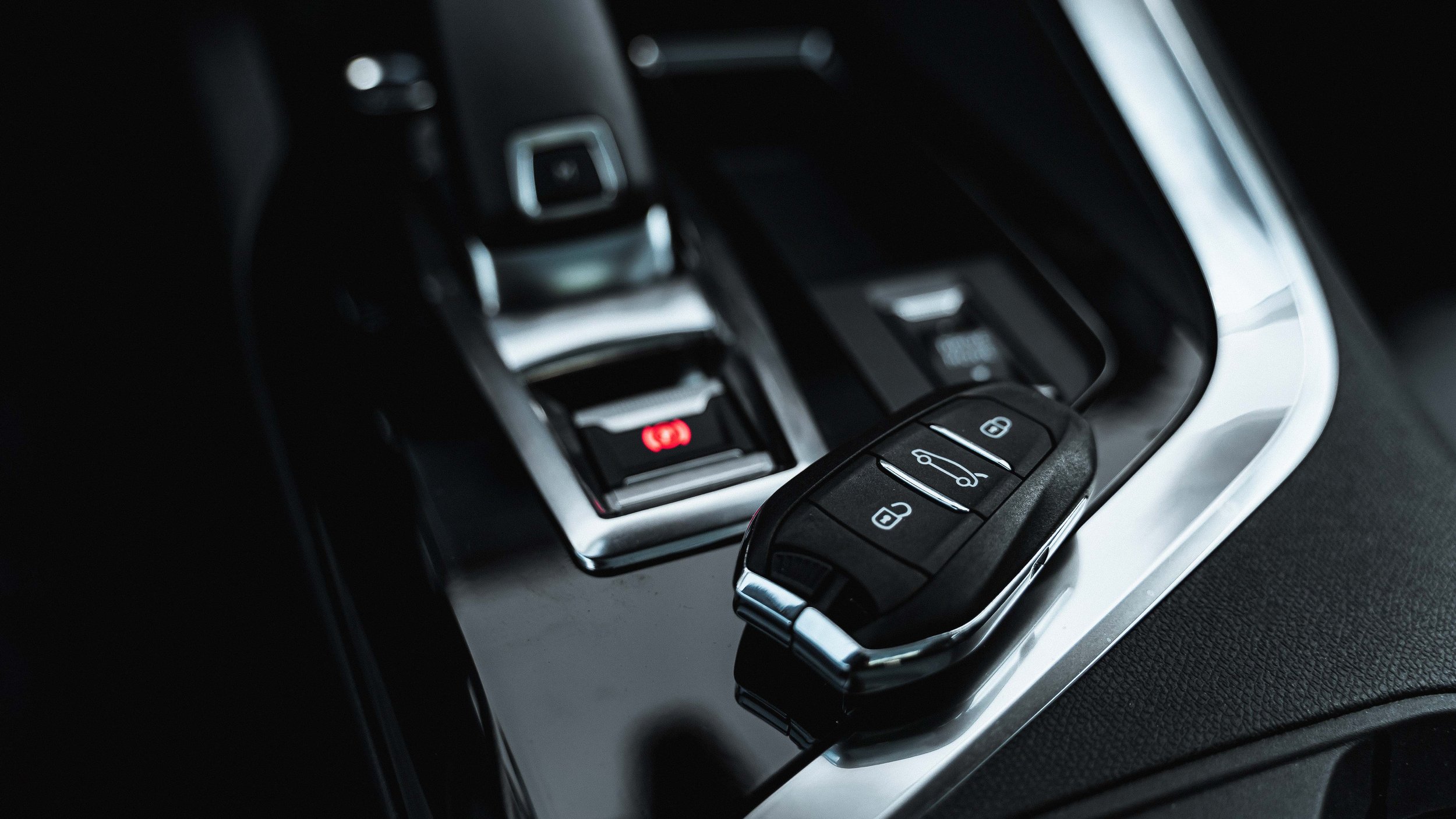 Vehicle key fob resting on a modern car center console, representing professional remote starter installation at Xtreme Car & Truck in Bridgeville, PA.