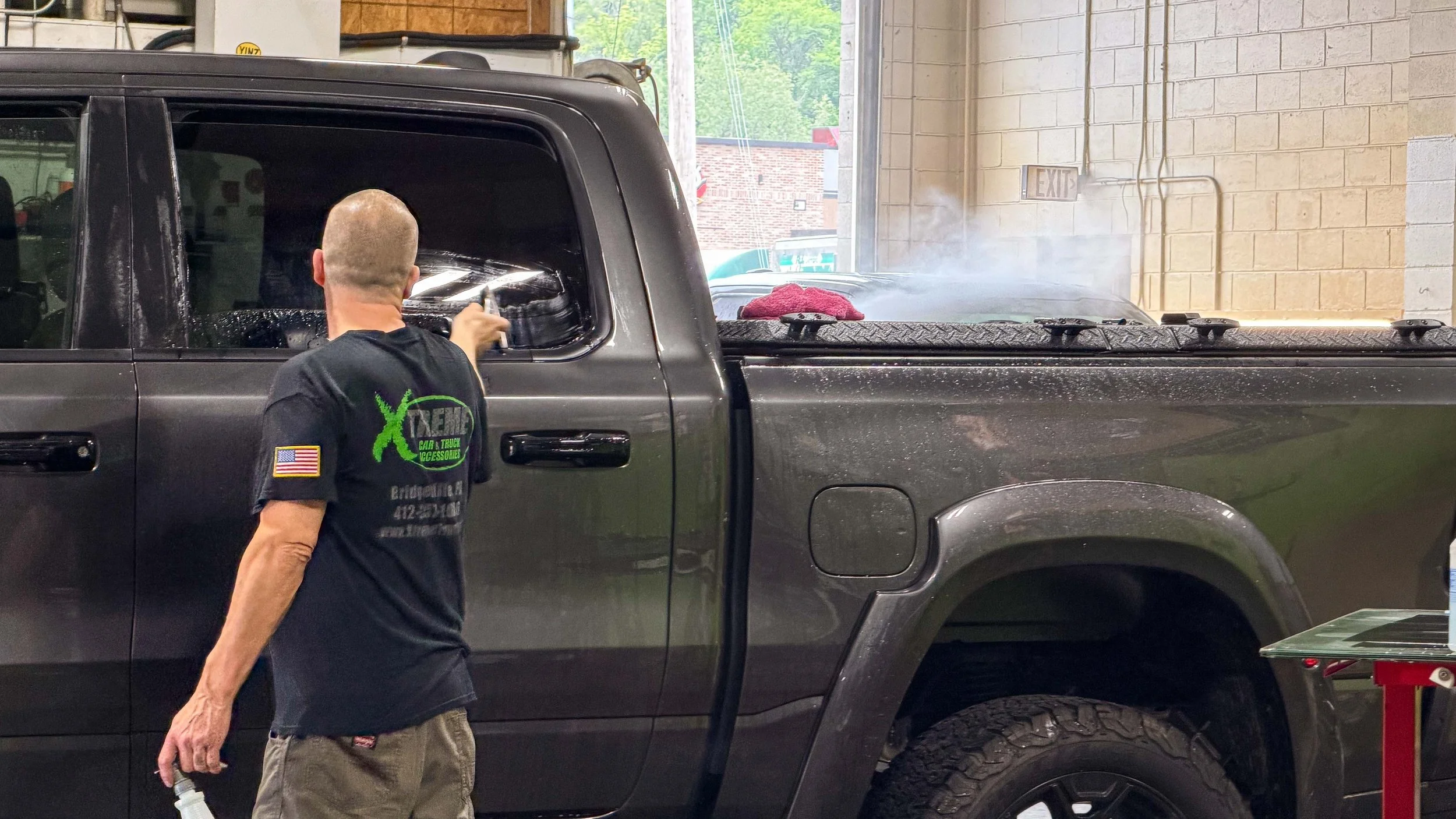 Xtreme technician finishing XPEL window tint on a pickup truck in Bridgeville PA, serving Pittsburgh and South Hills drivers