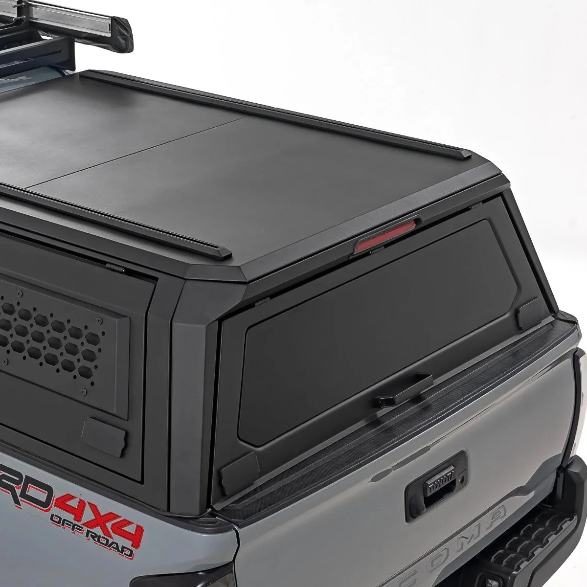 Black modular steel truck cap with side access panel and roof rails installed on a Toyota Tacoma, available through Xtreme Car & Truck Accessories in Bridgeville, PA.