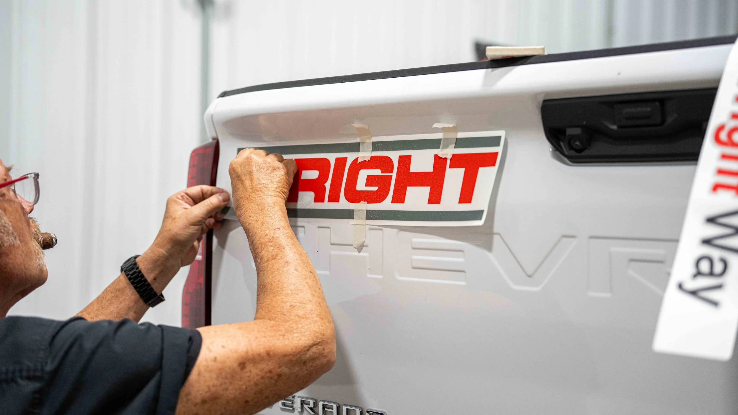 Custom W.D. Wright tailgate lettering being installed on a Chevrolet work truck by Xtreme Car and Truck Accessories in Bridgeville PA