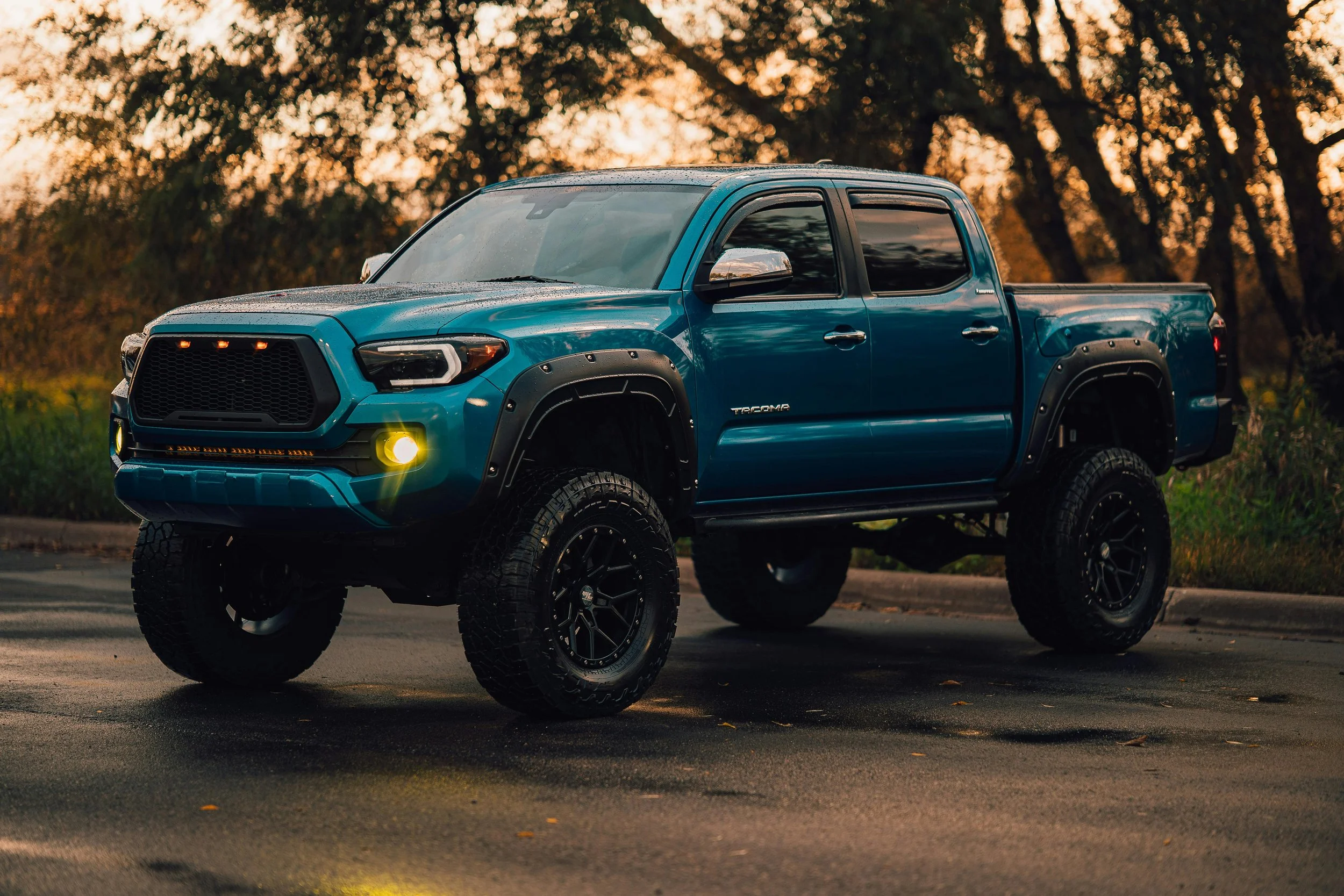 Lifted Toyota Tacoma with off-road wheels, fender flares, tinted windows, and upgraded suspension after a lift kit installation near Bridgeville, PA.