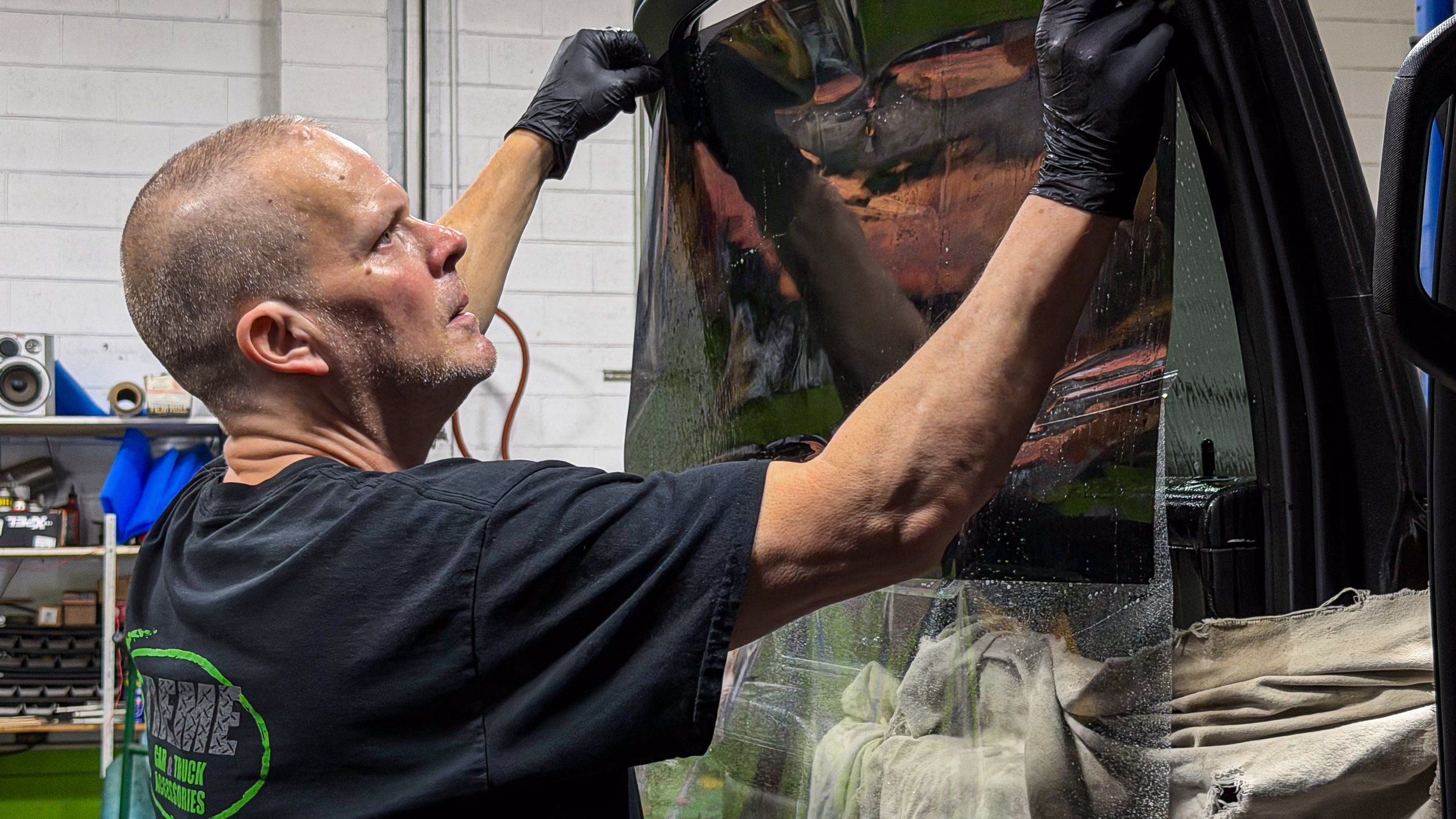 Xtreme technician applying XPEL automotive window tint film inside the Bridgeville PA shop near Pittsburgh