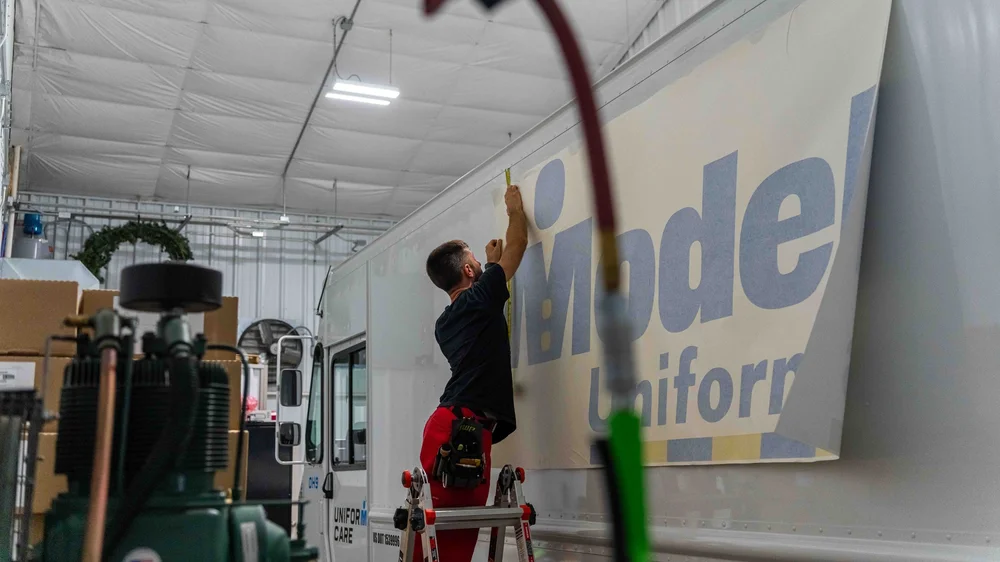 Model Uniforms rental delivery van showcasing professional van lettering, logo decals, and custom fleet graphics by Xtreme Car & Truck Accessories.