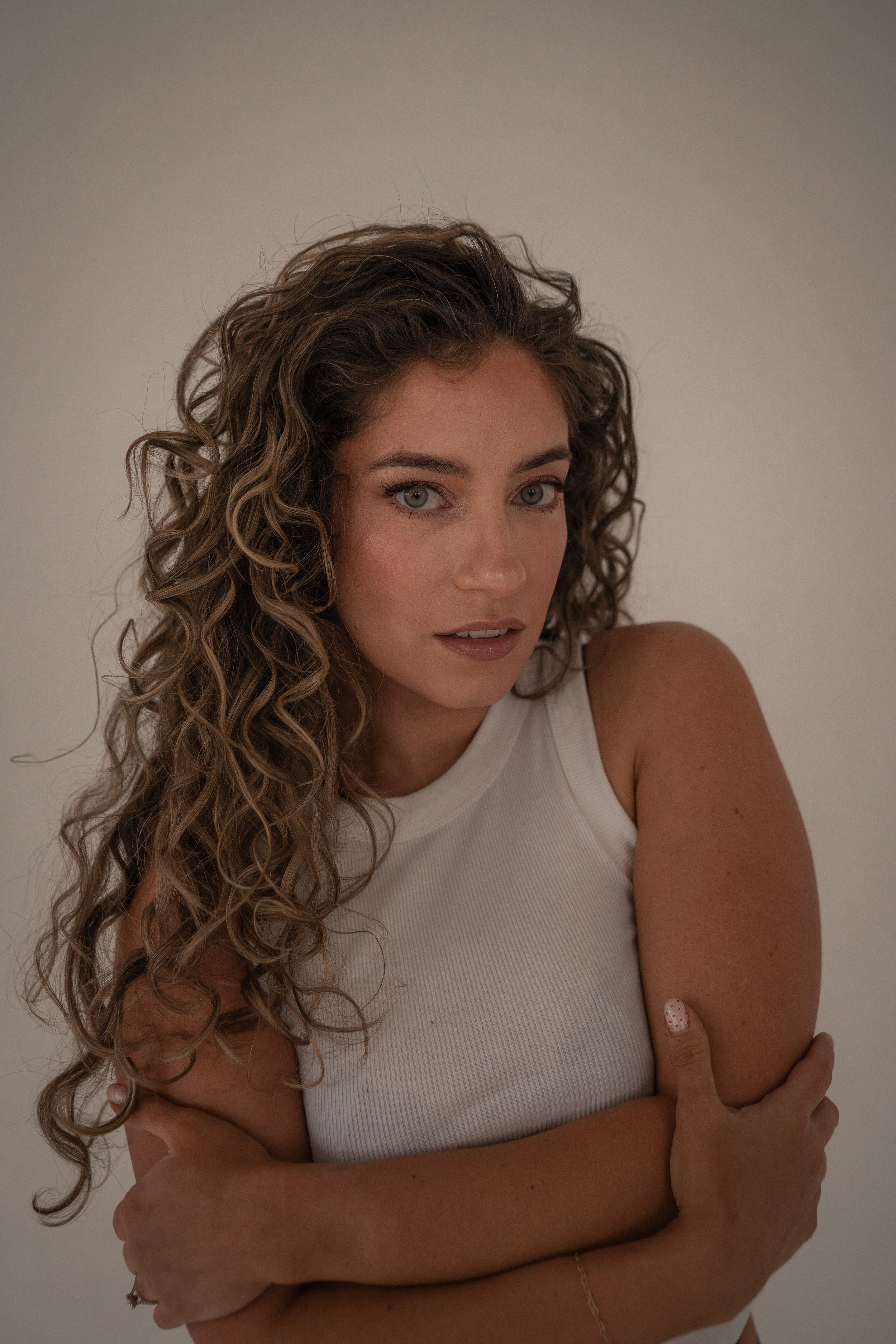 tanned woman standing against a wall