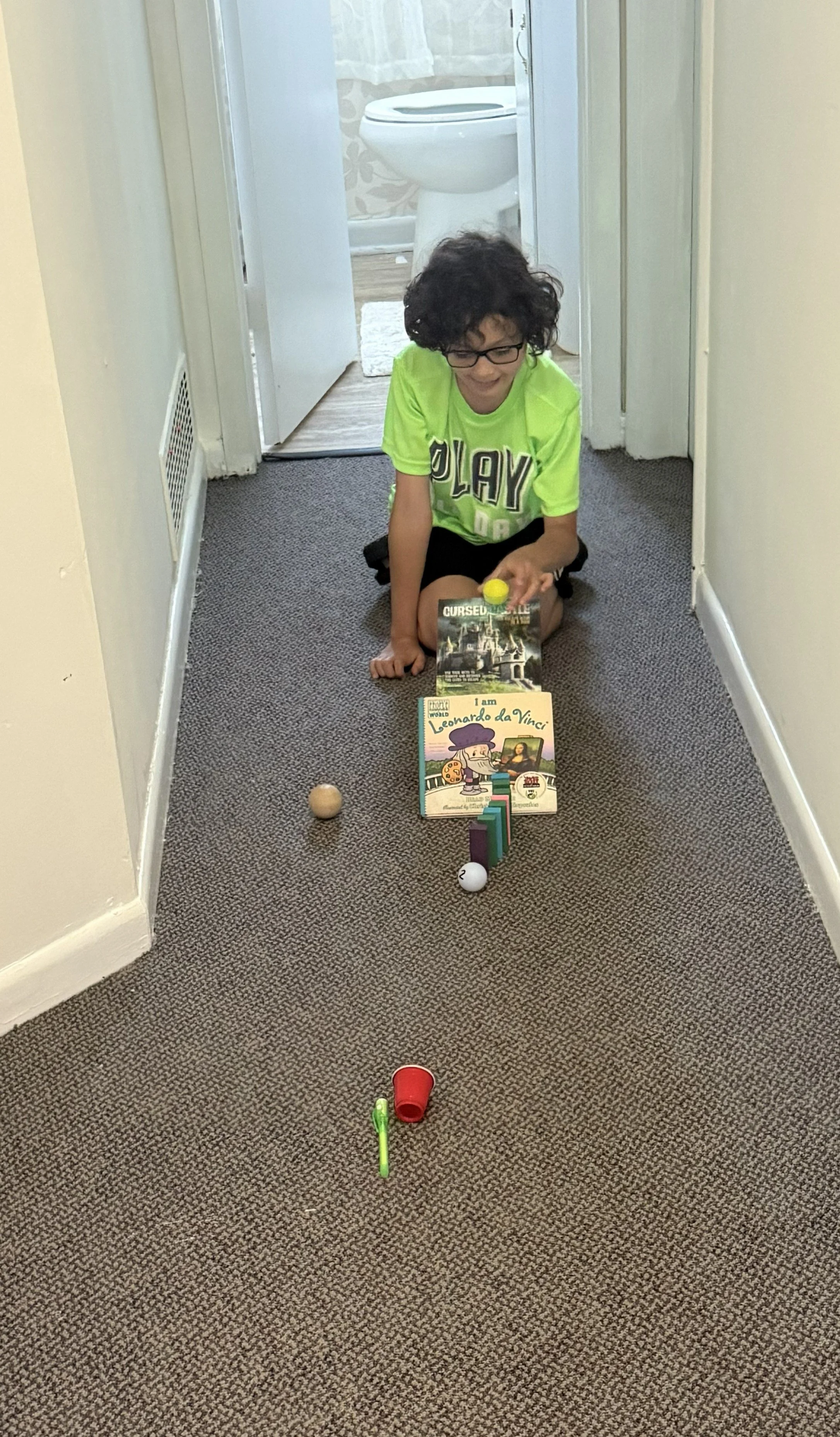 Student testing a Rube Goldberg-style build during a summer inquiry camp