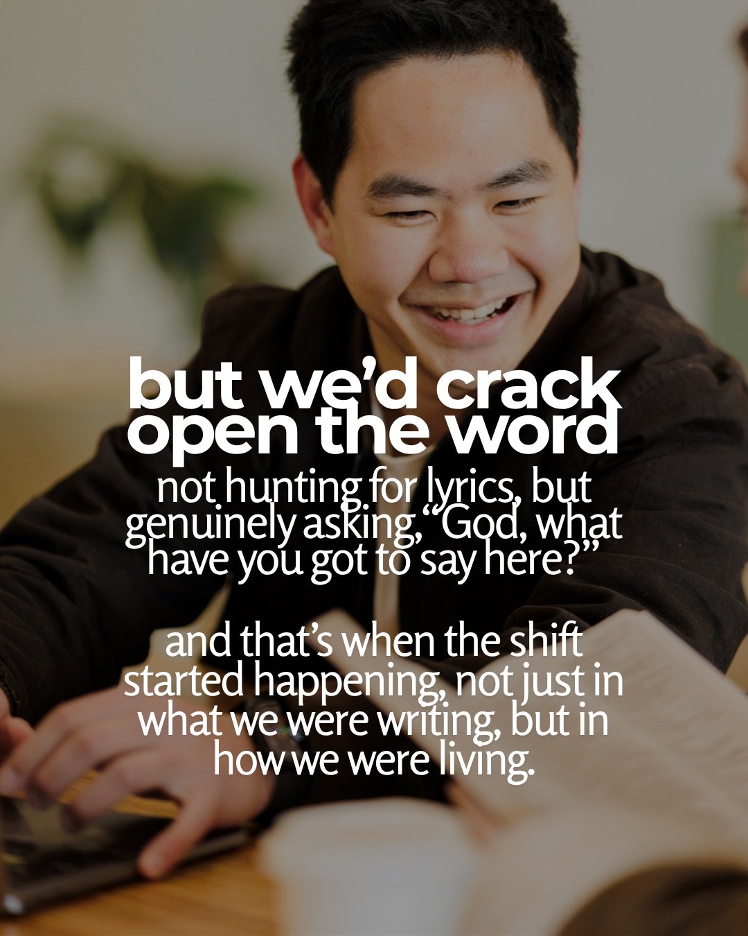 A smiling young man sits at a table beside an open book, in soft focus. Text: but we’d crack open the word not hunting for lyrics, but genuinely asking, “God, what have you got to say here?” and that’s when the shift started happening, not just in what we were writing, but in how we were living.