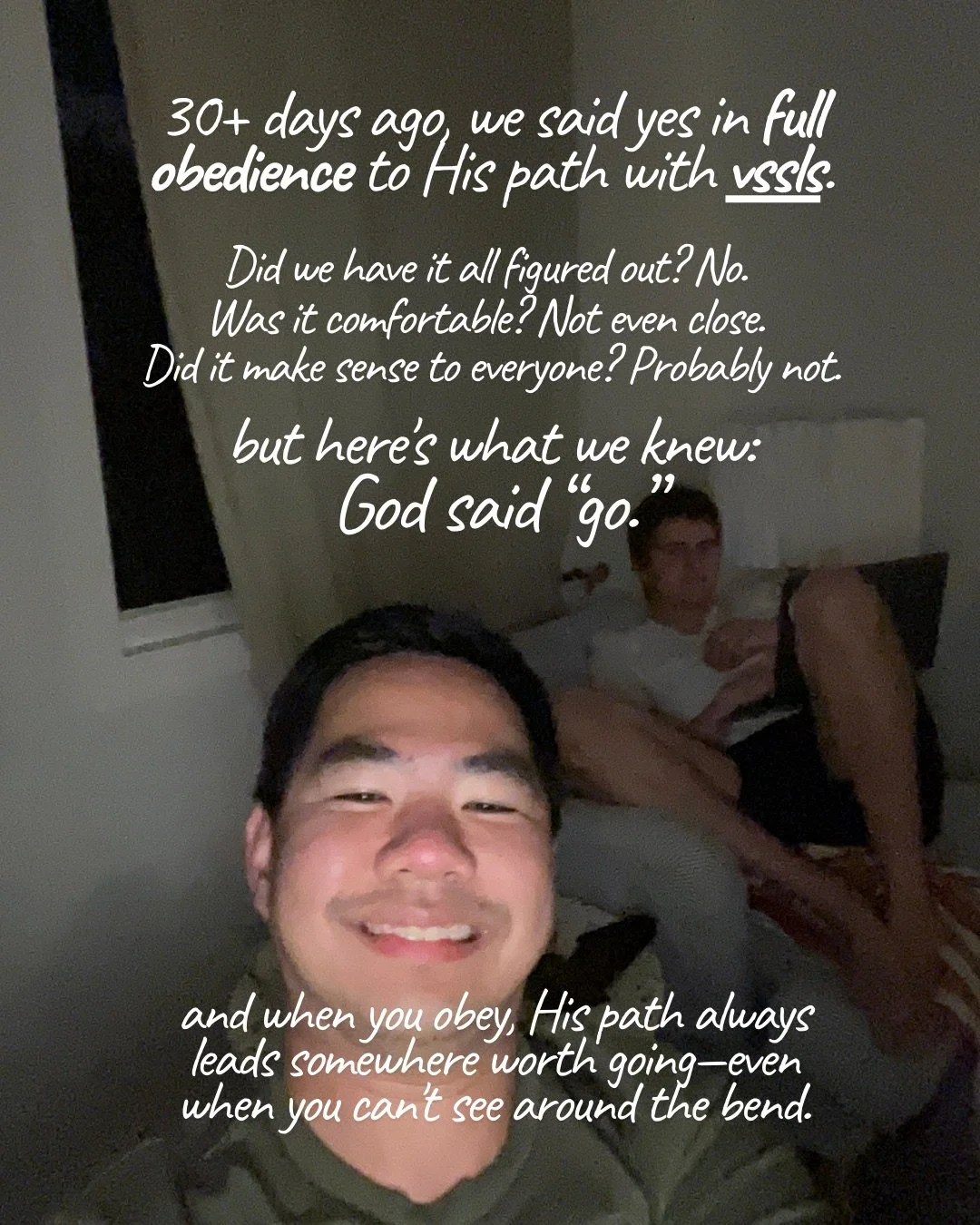 A dimly lit selfie of a smiling young man, with another young man relaxing on a couch behind him. Text: 30+ days ago, we said yes in full obedience to His path with vssls. Did we have it all figured out? No. Was it comfortable? Not even close. Did it make sense to everyone? Probably not. but here's what we knew: God said “go.” and when you obey, His path always leads somewhere worth going—even when you can't see around the bend.