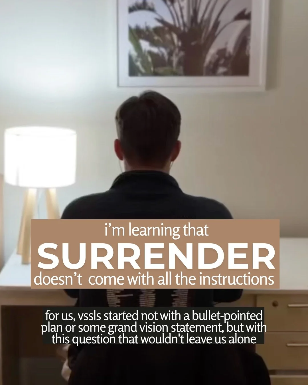 A young man sits at a desk with his back to the camera, beside a lit lamp and beneath a framed palm print. Text: i’m learning that surrender doesn’t come with all the instructions for us, vssls started not with a bullet-pointed plan or some grand vision statement, but with this question that wouldn't leave us alone