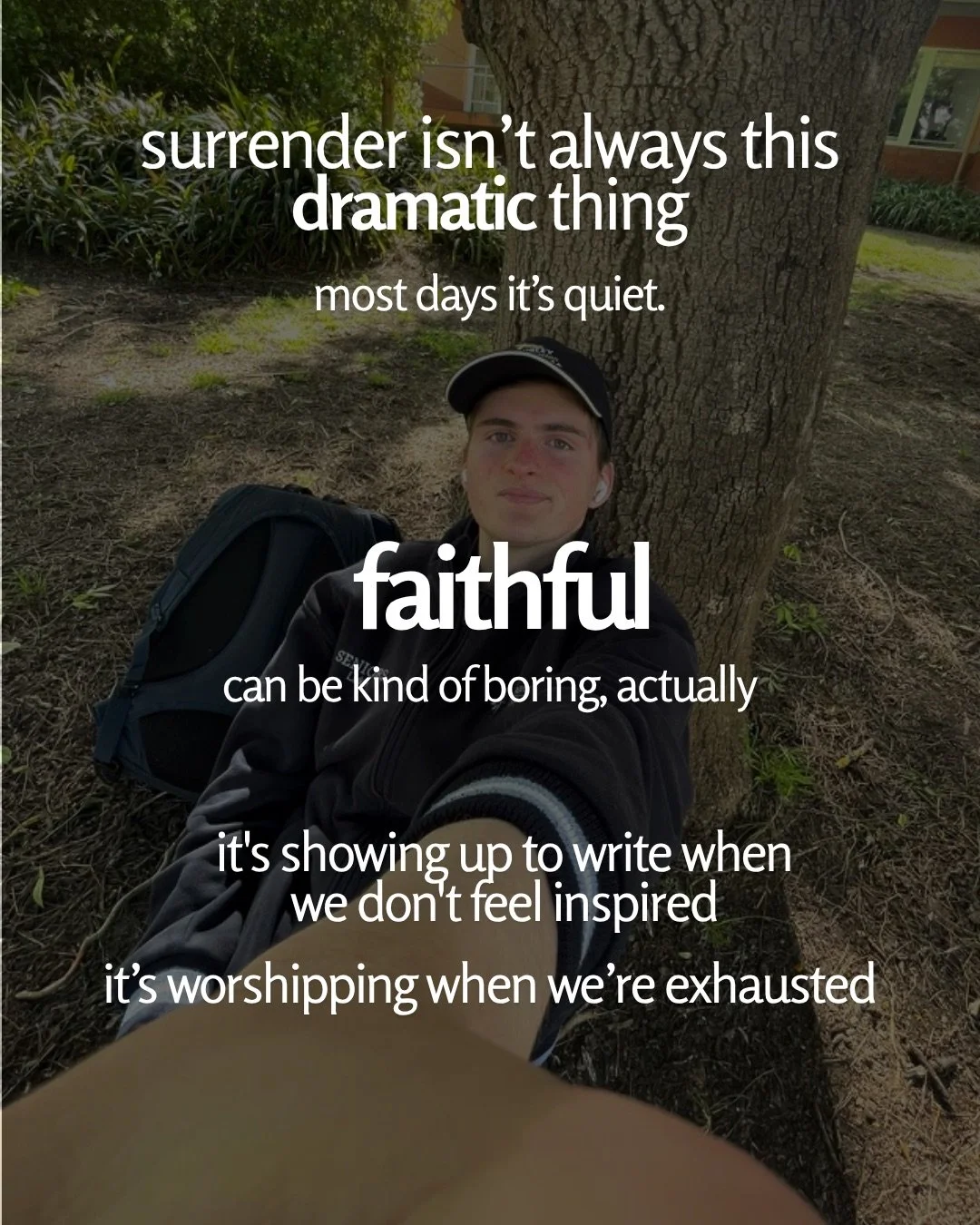 A young man in a cap sits against a tree trunk beside a backpack, taking a selfie. Text: surrender isn’t always this dramatic thing most days it’s quiet. faithful can be kind of boring, actually it's showing up to write when we don't feel inspired it’s worshipping when we’re exhausted