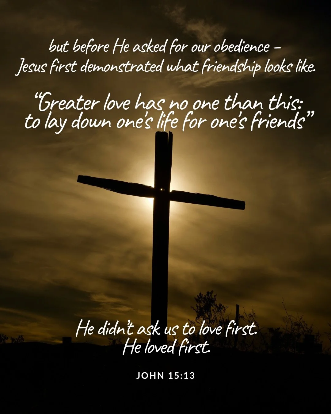 A wooden cross stands silhouetted against a sunlit, cloudy sky. Text: but before He asked for our obedience – Jesus first demonstrated what friendship looks like. “Greater love has no one than this: to lay down one's life for one's friends” He didn’t ask us to love first. He loved first. John 15:13