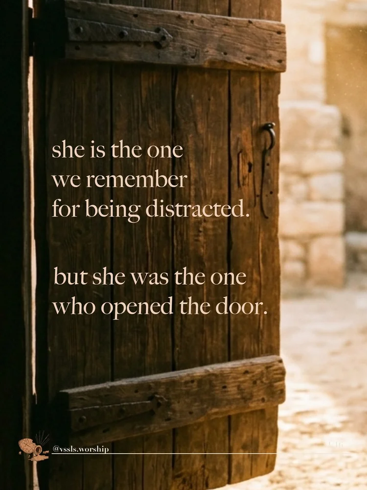 A weathered wooden door standing ajar onto a sunlit lane. Text: she is the one we remember for being distracted. but she was the one who opened the door.