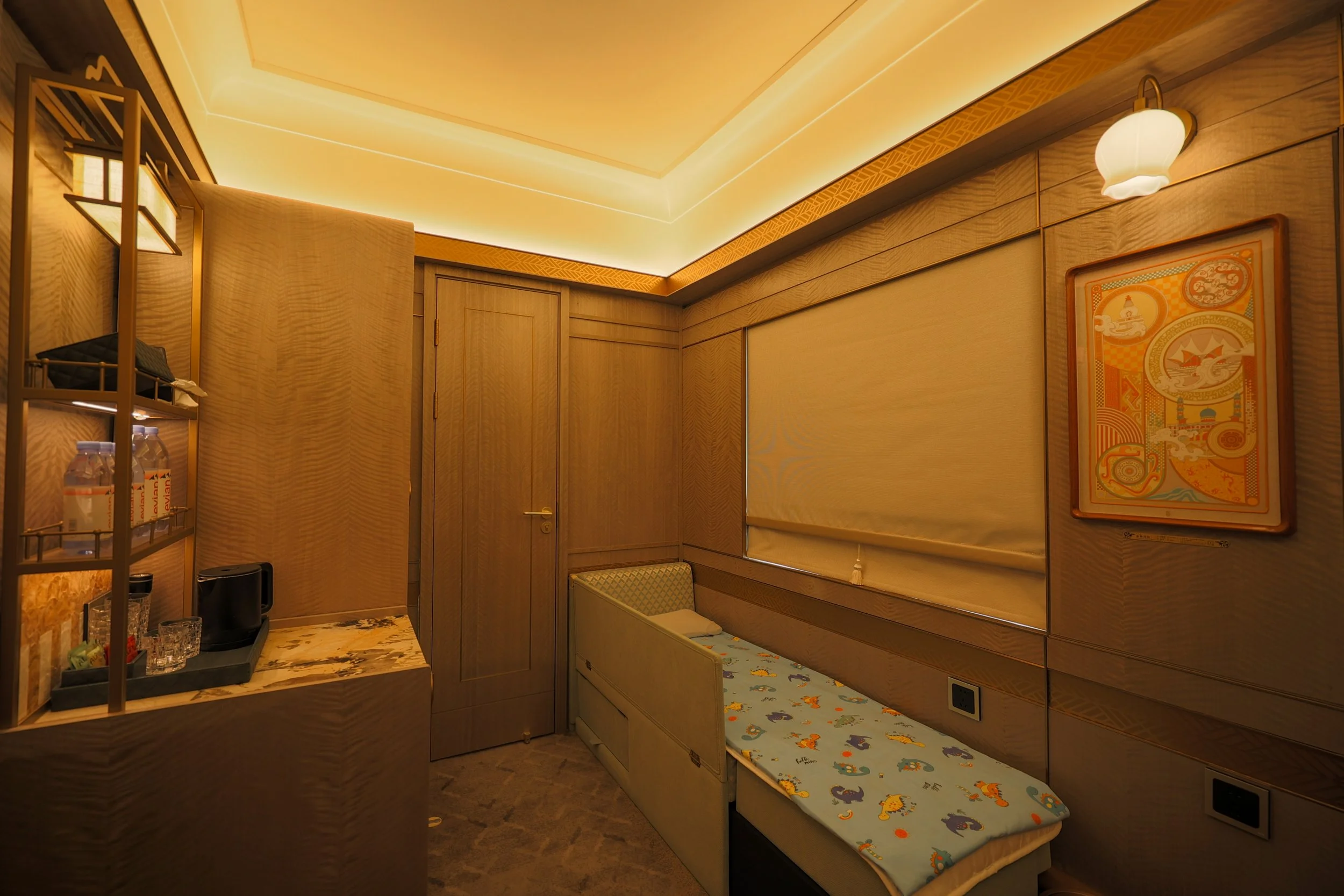 Child's bed made up with printed bedding along the wall of the Deluxe Suite (Family)