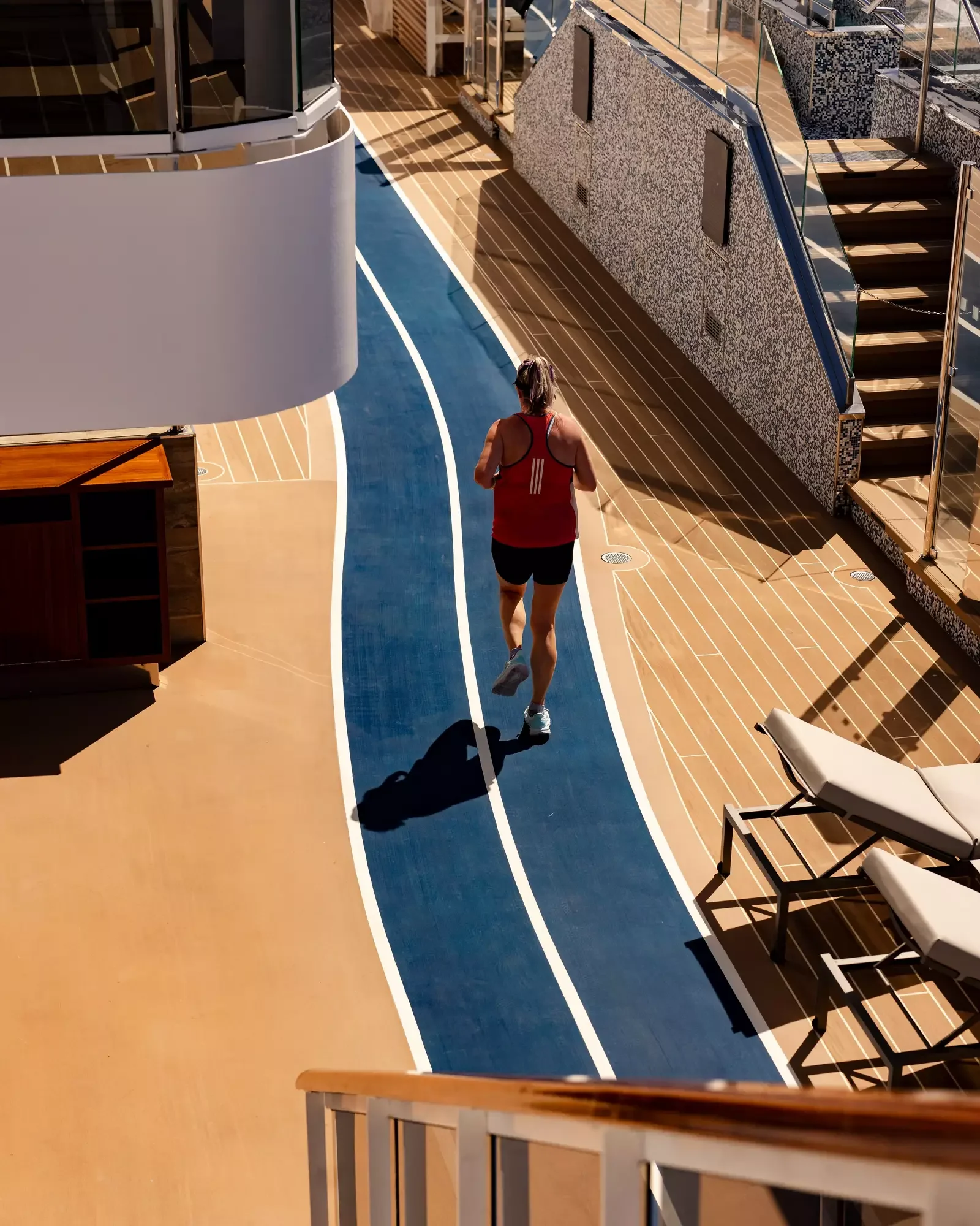 Guest jogging on the open-deck running track of EXPLORA II
