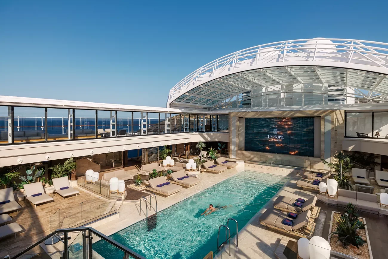 Guest swimming in the Conservatory Pool under the retractable glass roof on EXPLORA II