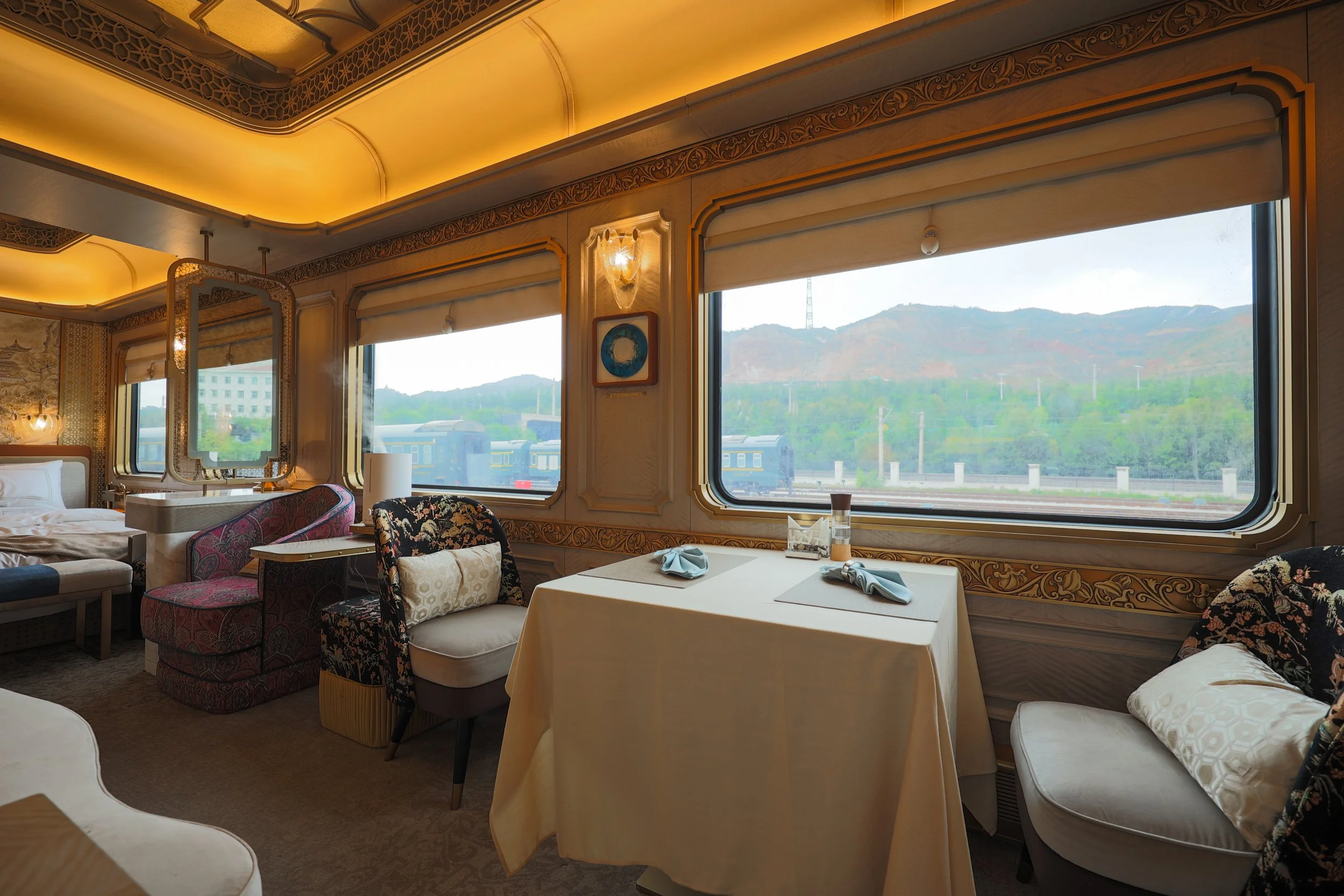 Table for two in the Silk Road Express Grand Suite, with the minibar and bathroom towels behind