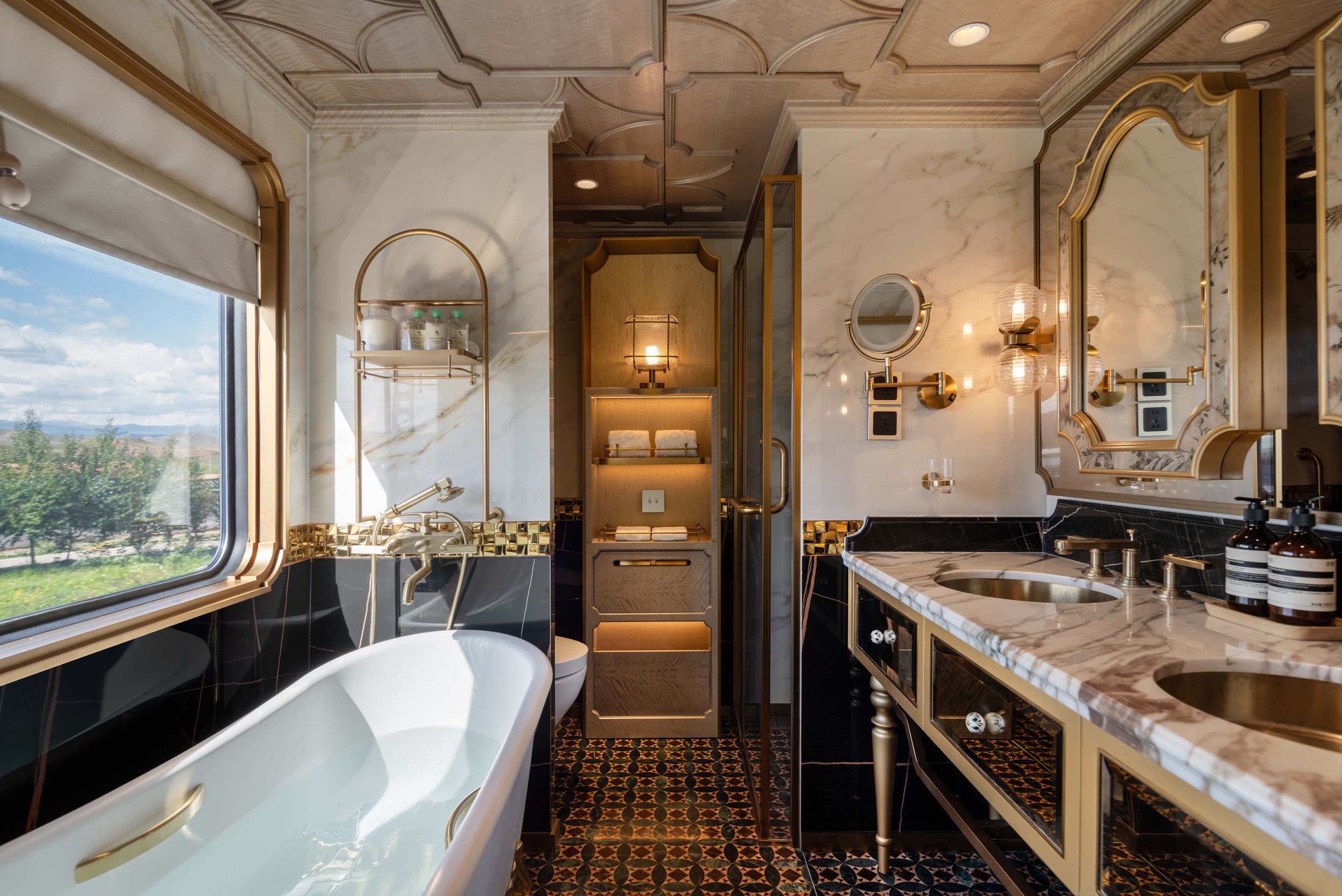 Silk Road Express Grand Suite bathroom with a bathtub by the window and double brass washbasins