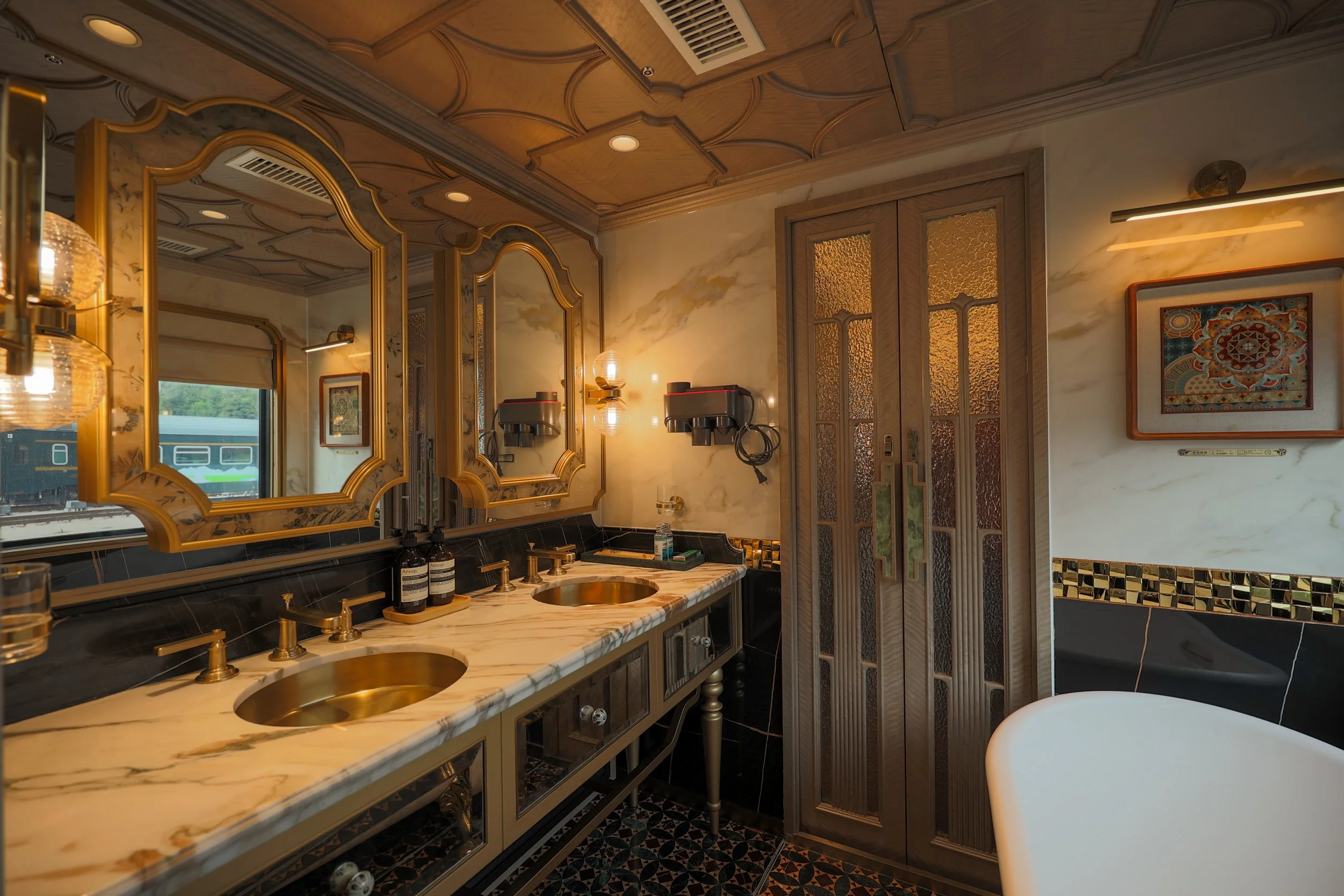 Grand Suite marble double vanity with brass basins, gilded mirrors and glazed double doors