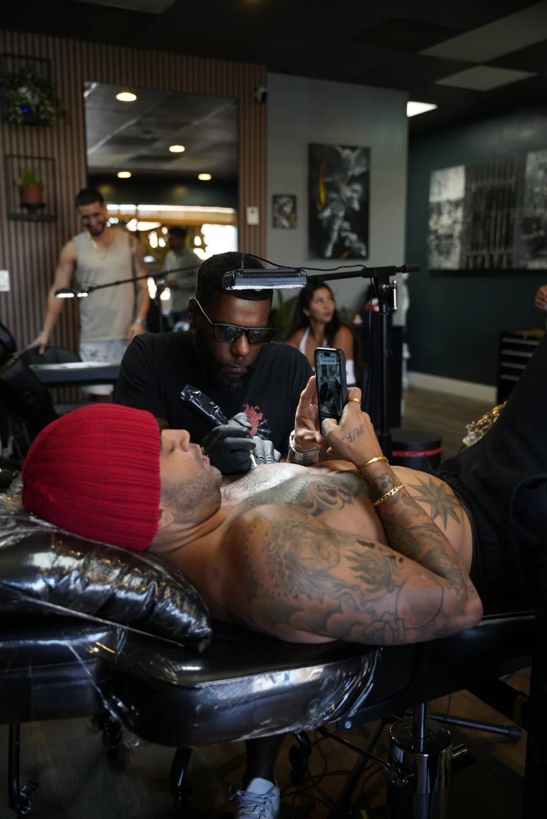 Tattoo session with a client wearing a red beanie at Black Nova