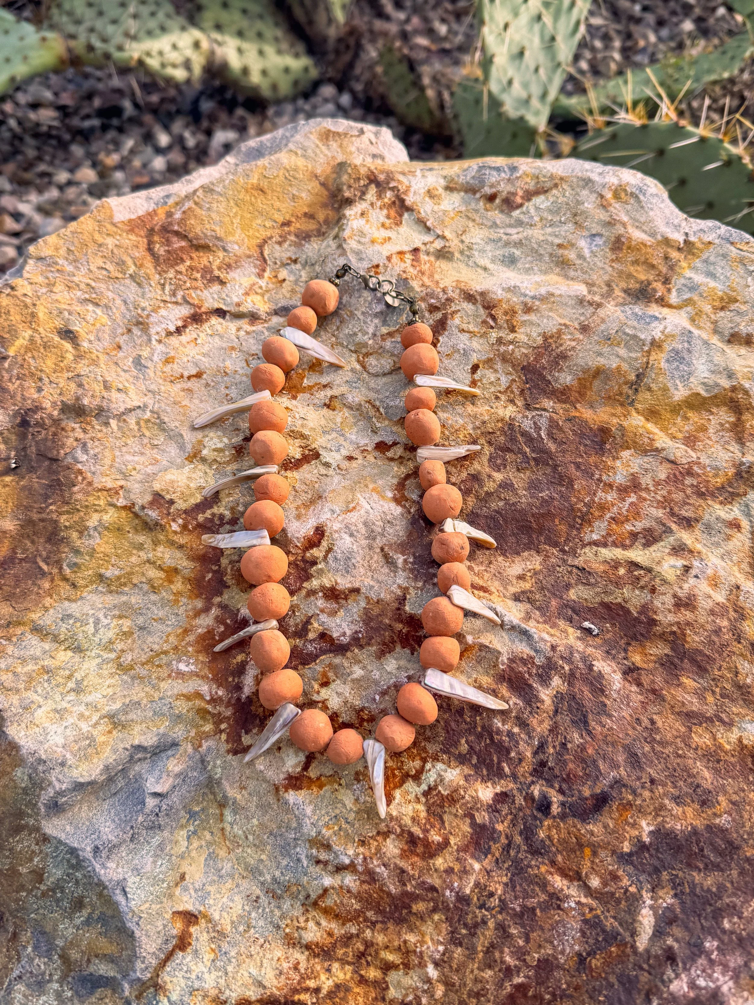 Clay bead necklace resting on desert stone