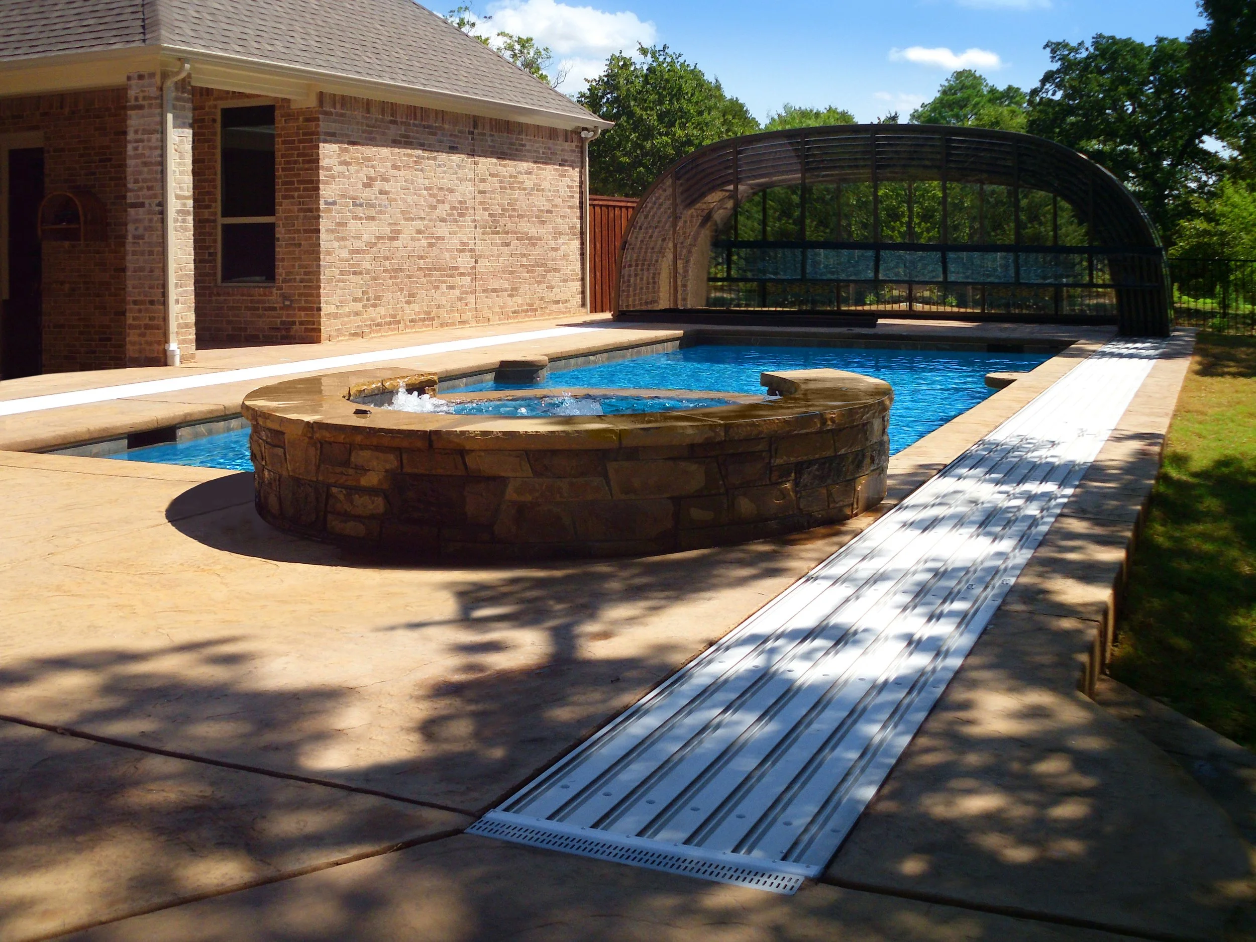 Laguna retractable pool enclosure with recessed tracks set into the deck