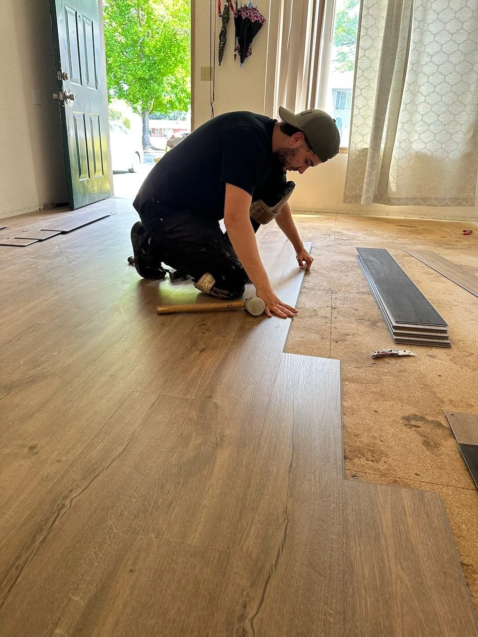 Sannikov team member fitting plank flooring during an installation