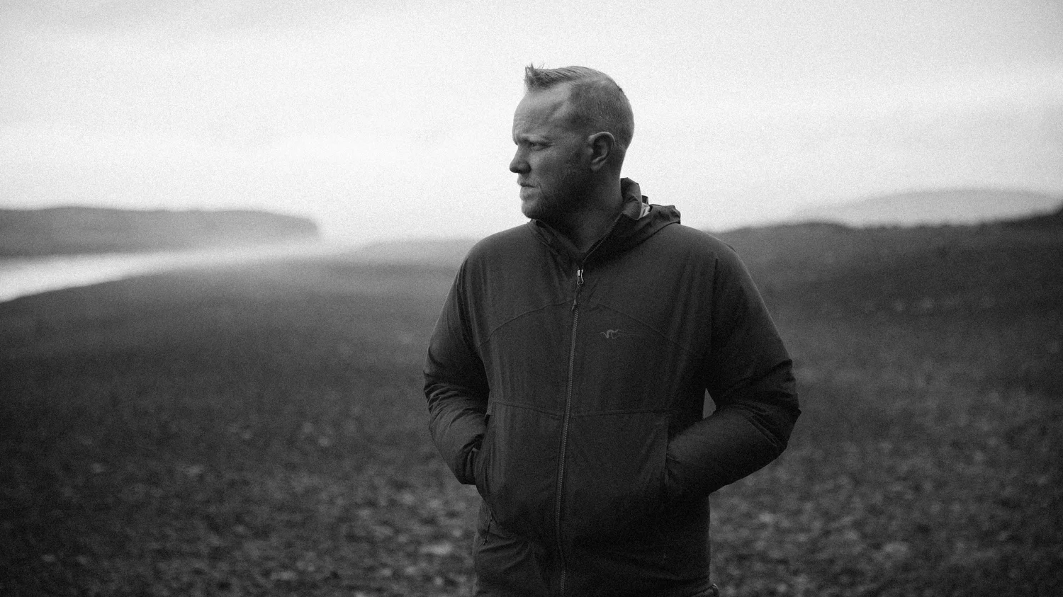 Cody Silver standing on a misty beach in Iceland, black and white