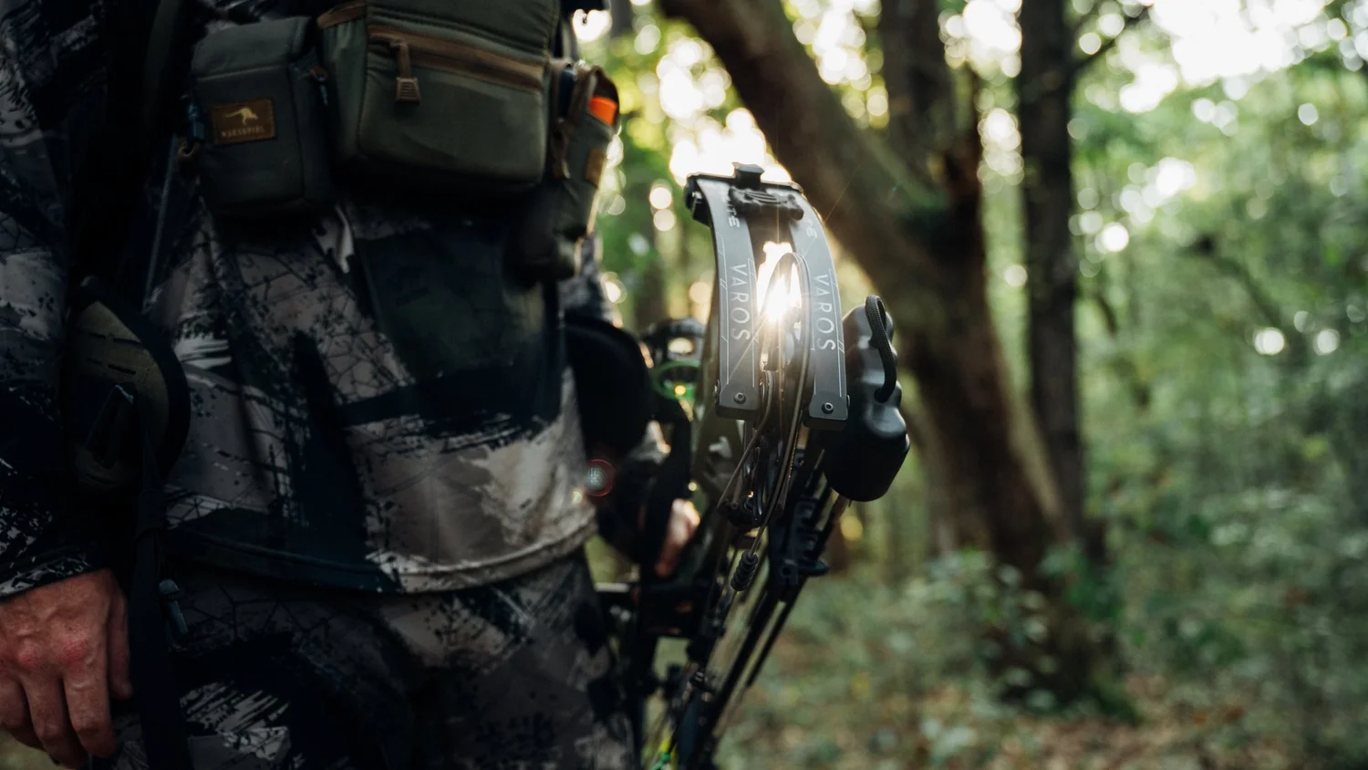 Bowhunter in camo holding a bow in the woods