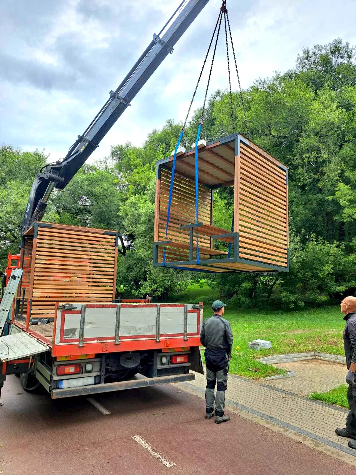 Kranas kelia pavėsinės konstrukciją nuo priekabos