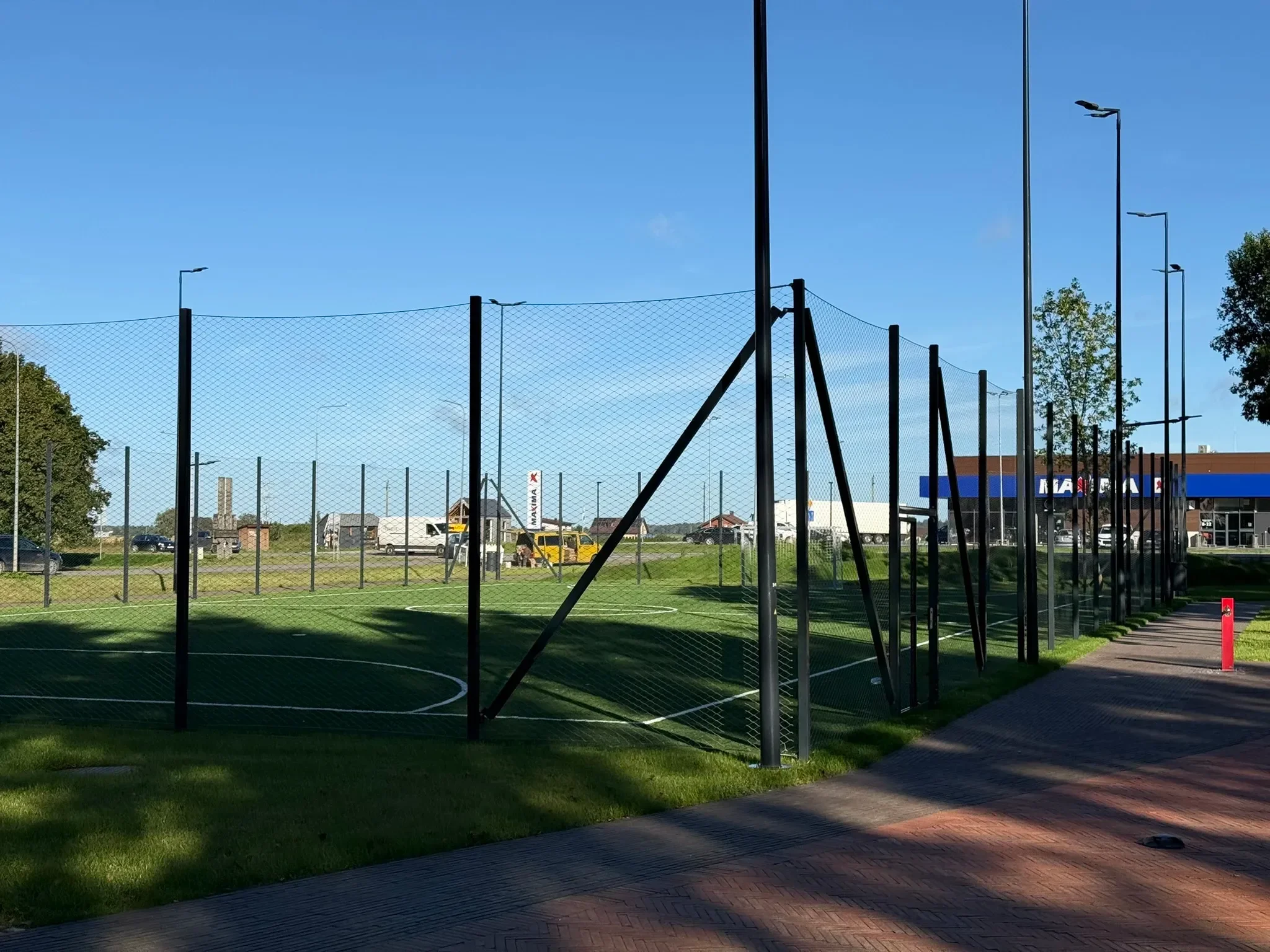 Aptvaro stulpai ir įtempimo diagonalės prie futbolo aikštelės