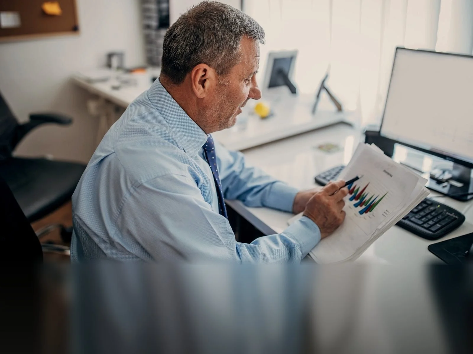 Finance director reviewing figures at his office desk