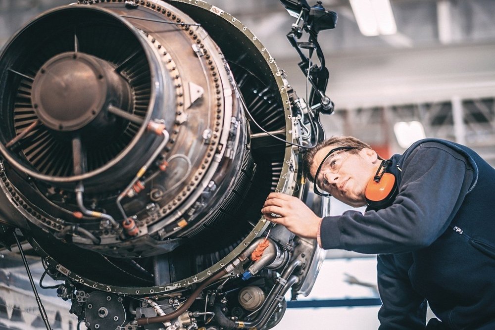 Engineer inspecting an aircraft jet engine during maintenance