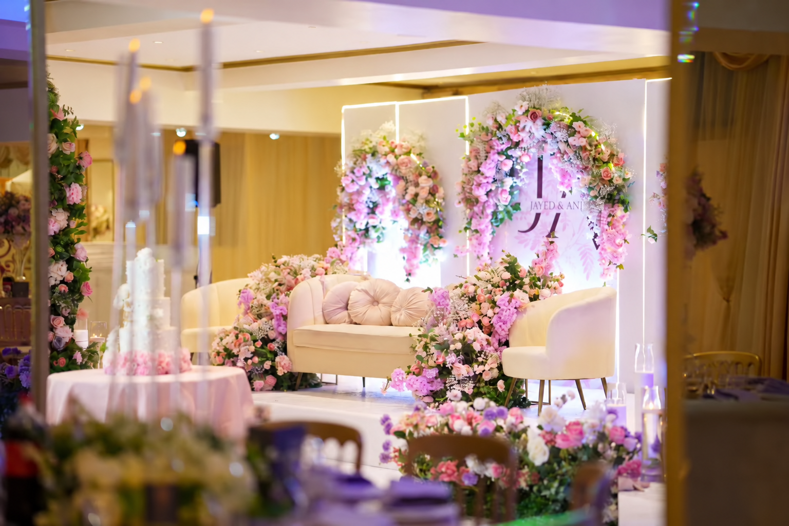 Pastel floral arches and cream seating