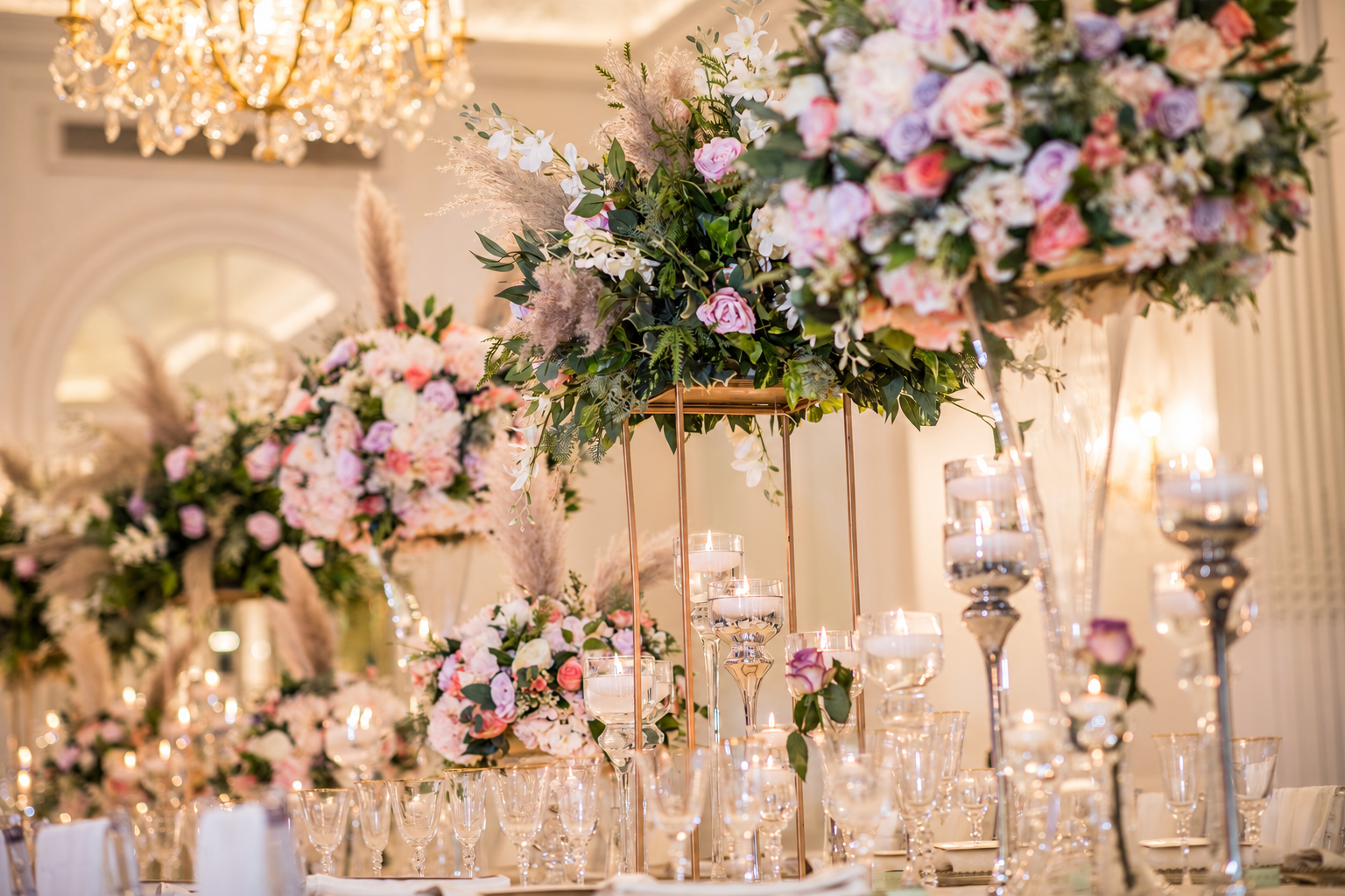 Pink and white floral centrepieces in a Mubarak Events reception setting