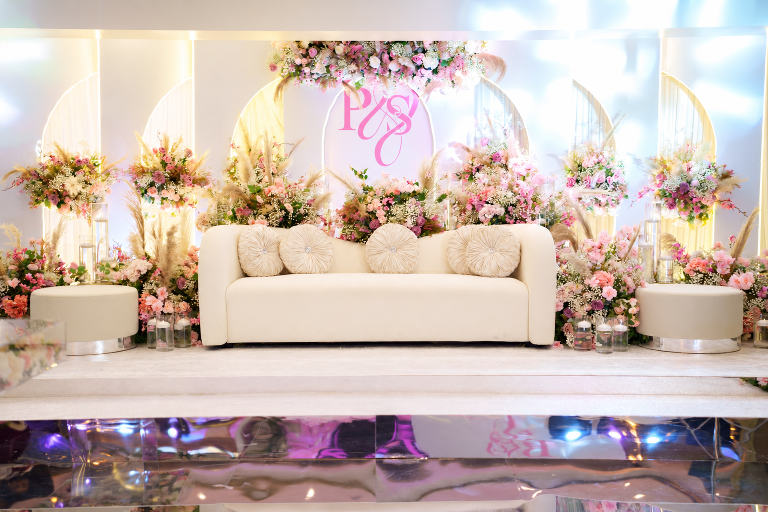 A white wedding stage surrounded by pastel flowers