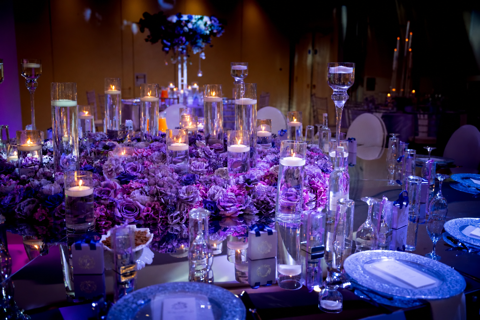 Floating candles and purple flowers around a reception table